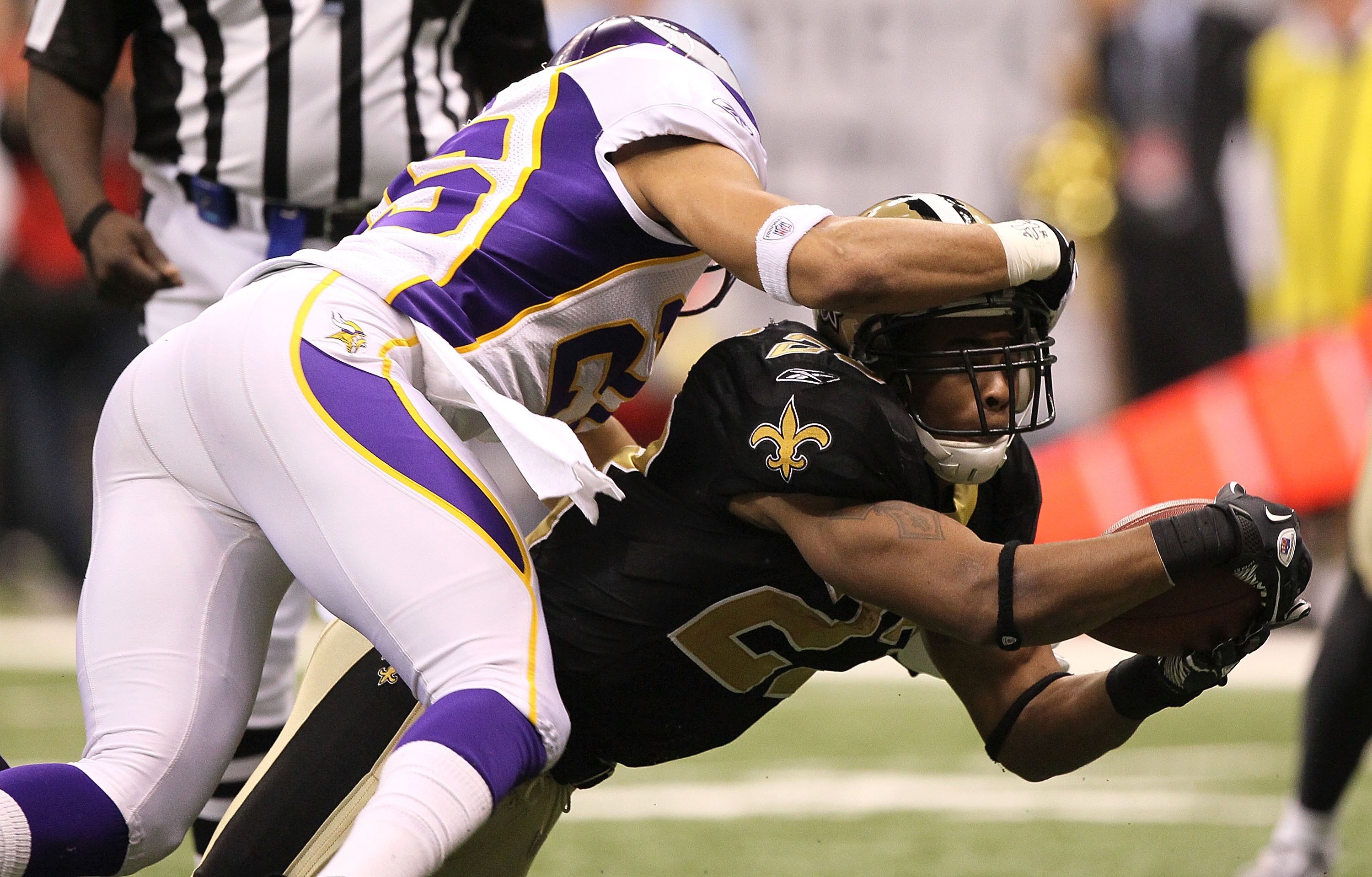 NEW ORLEANS - JANUARY 24: Pierre Thomas #23 of the New Orleans Saints stretches to score a 3-yard rushing touchdown in the third quarter against Tyrell Johnson #25  the Minnesota Vikings during the NFC Championship Game at the Louisiana Superdome on Janua