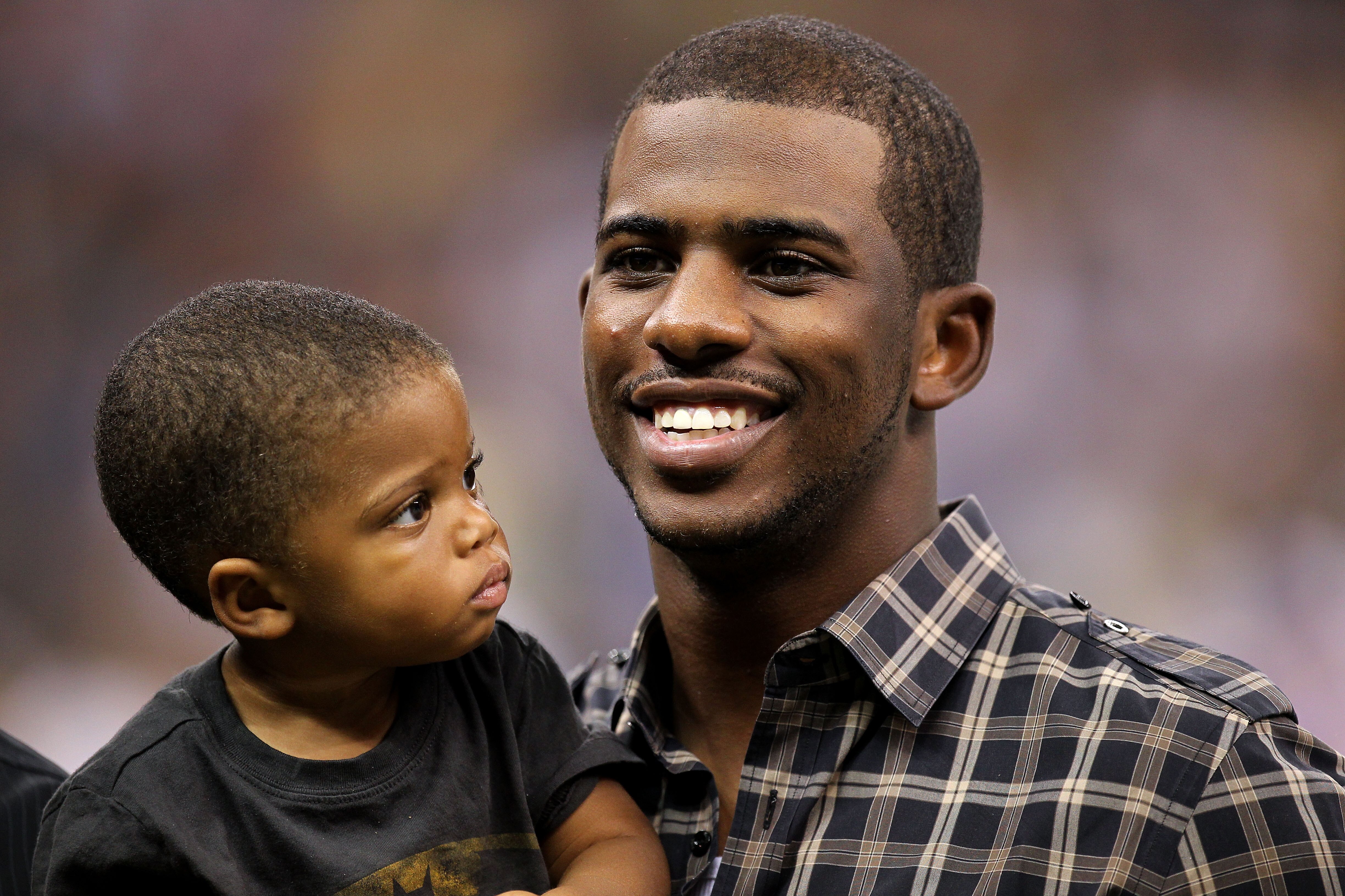 NEW ORLEANS - SEPTEMBER 09:  Chris Paul of the NBA's New Orleans Hornets holds his son Christopher as he stands on the sideline prior to the New Orleans Saints playing against the Minnesota Vikings at Louisiana Superdome on September 9, 2010 in New Orlean