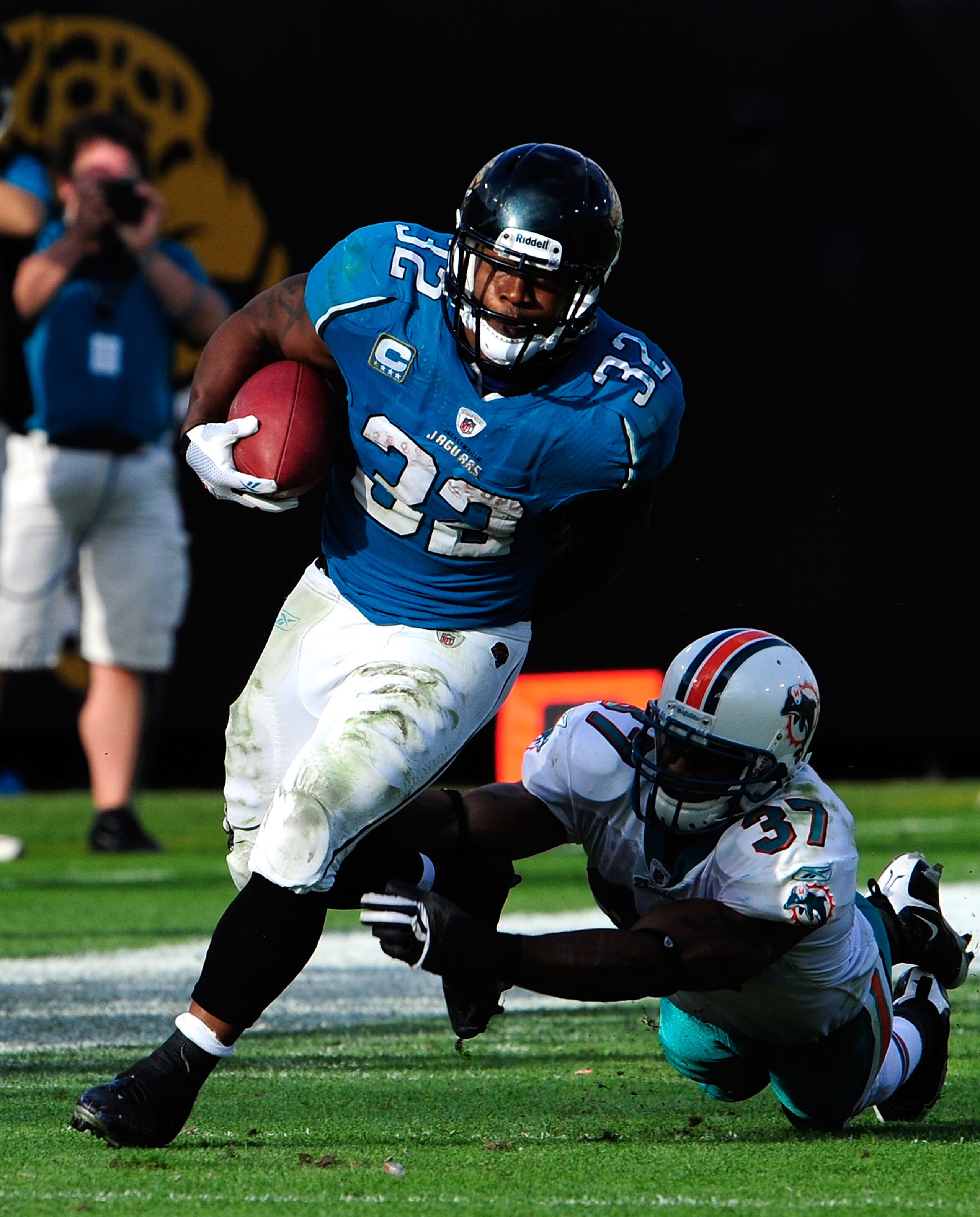 JACKSONVILLE, FL - DECEMBER 13:  Maurice Jones-Drew #32 of the Jacksonville Jaguars runs the ball against Yeremiah Bell #37 of the Miami Dolphins during the game at Jacksonville Municipal Stadium on December 13, 2009 in Jacksonville, Florida.  The Dolphin