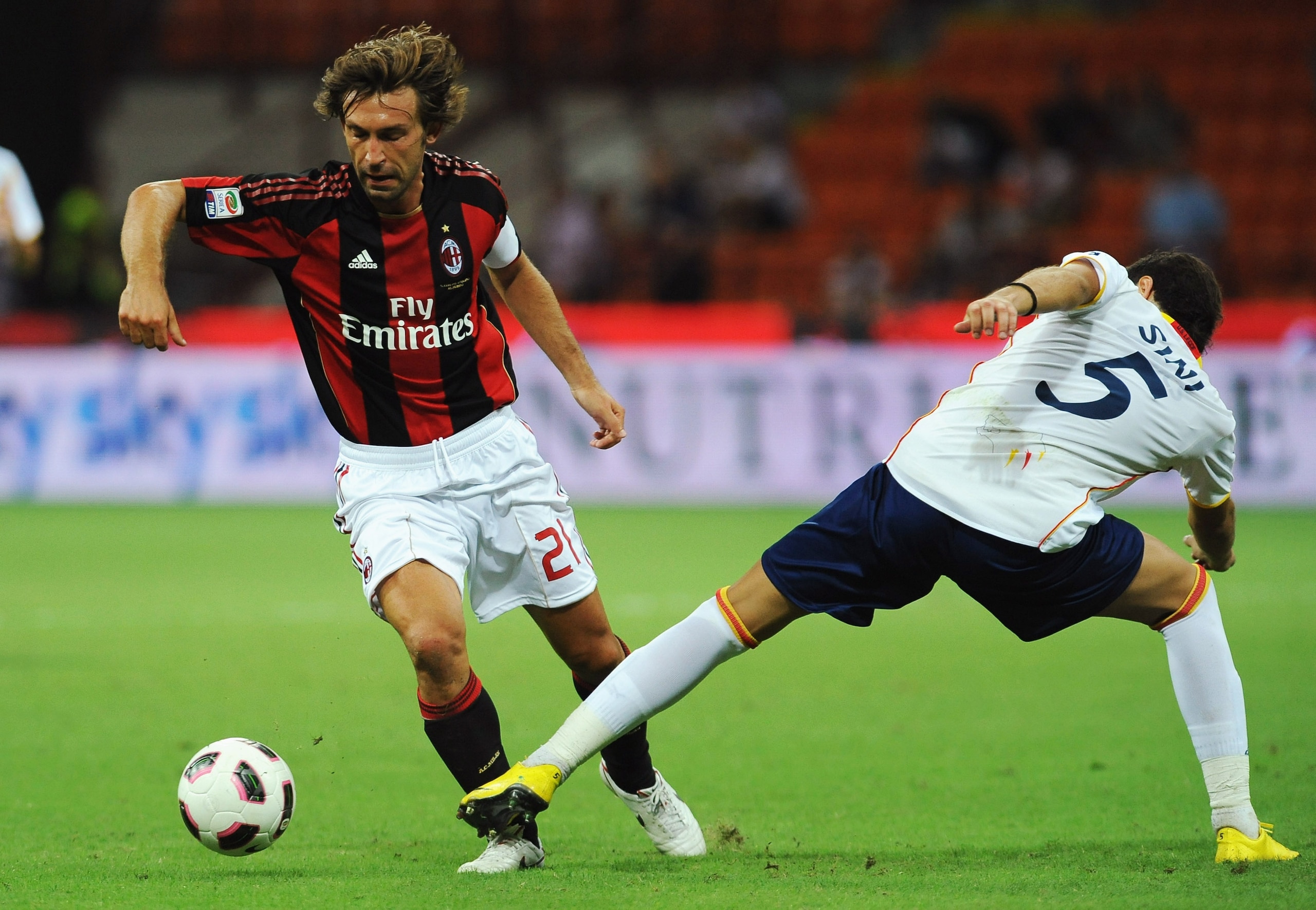 MILAN, ITALY - AUGUST 29:  Andrea Pirlo of AC Milan is challenged by Simone Sini of US Lecce during the Serie A match between AC Milan and US Lecce at Stadio Giuseppe Meazza on August 29, 2010 in Milan, Italy.  (Photo by Valerio Pennicino/Getty Images)