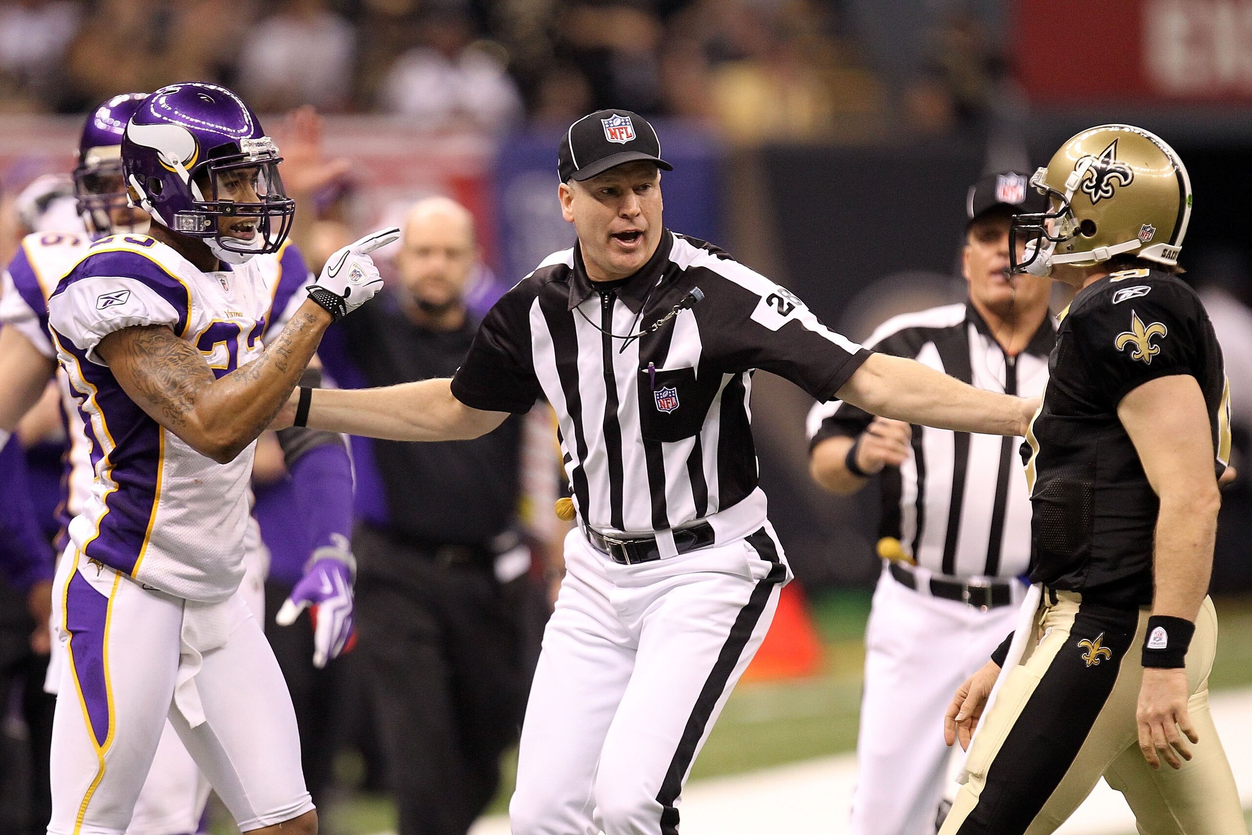 NEW ORLEANS - JANUARY 24:  Head linesman Mark Hittner seperates Drew Brees #9 of the New Orleans Saints and Cedric Griffin #23 of the Minnesota Vikings during the NFC Championship Game at the Louisana Superdome on January 24, 2010 in New Orleans, Louisian