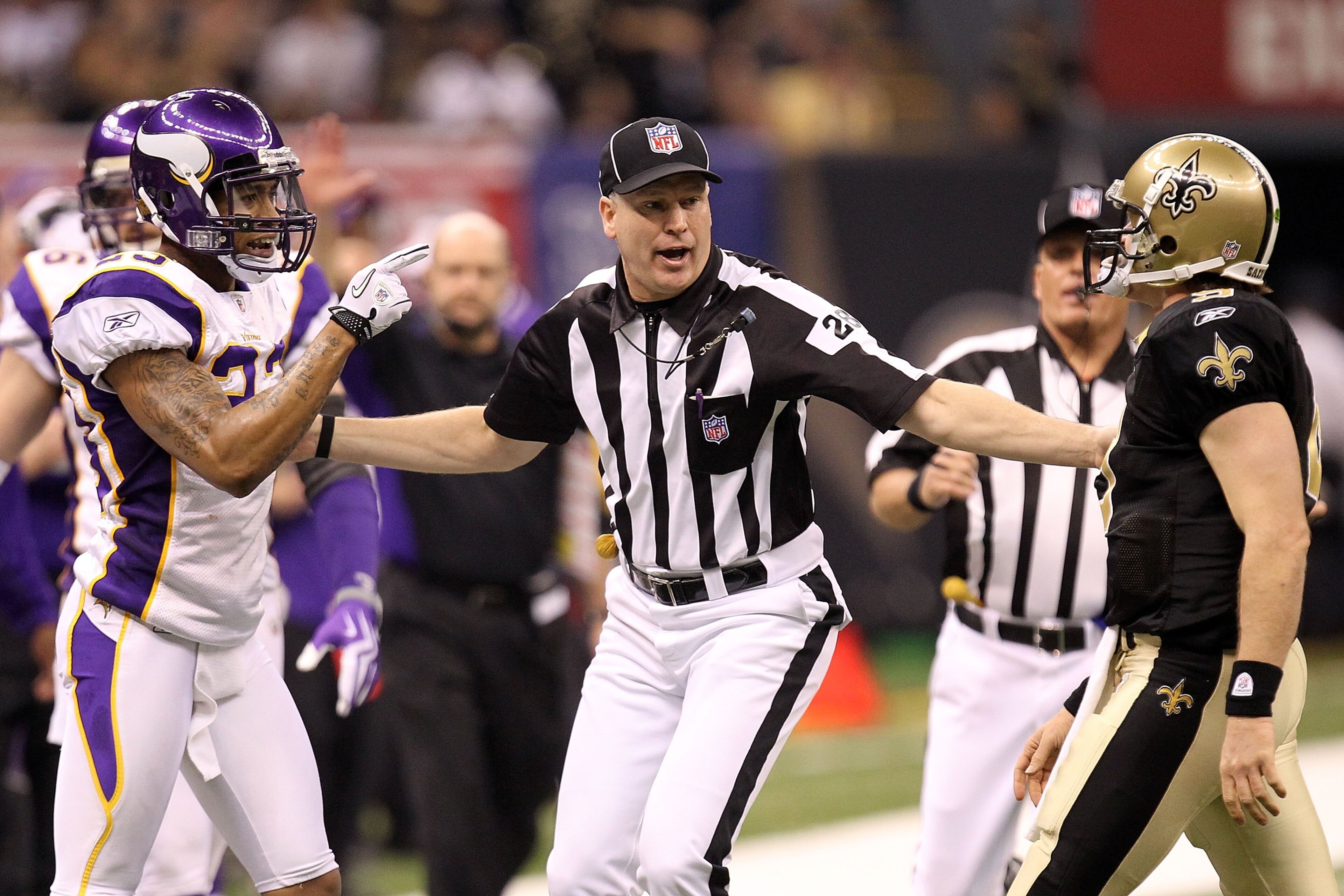 NEW ORLEANS - JANUARY 24:  Head linesman Mark Hittner seperates Drew Brees #9 of the New Orleans Saints and Cedric Griffin #23 of the Minnesota Vikings during the NFC Championship Game at the Louisana Superdome on January 24, 2010 in New Orleans, Louisian