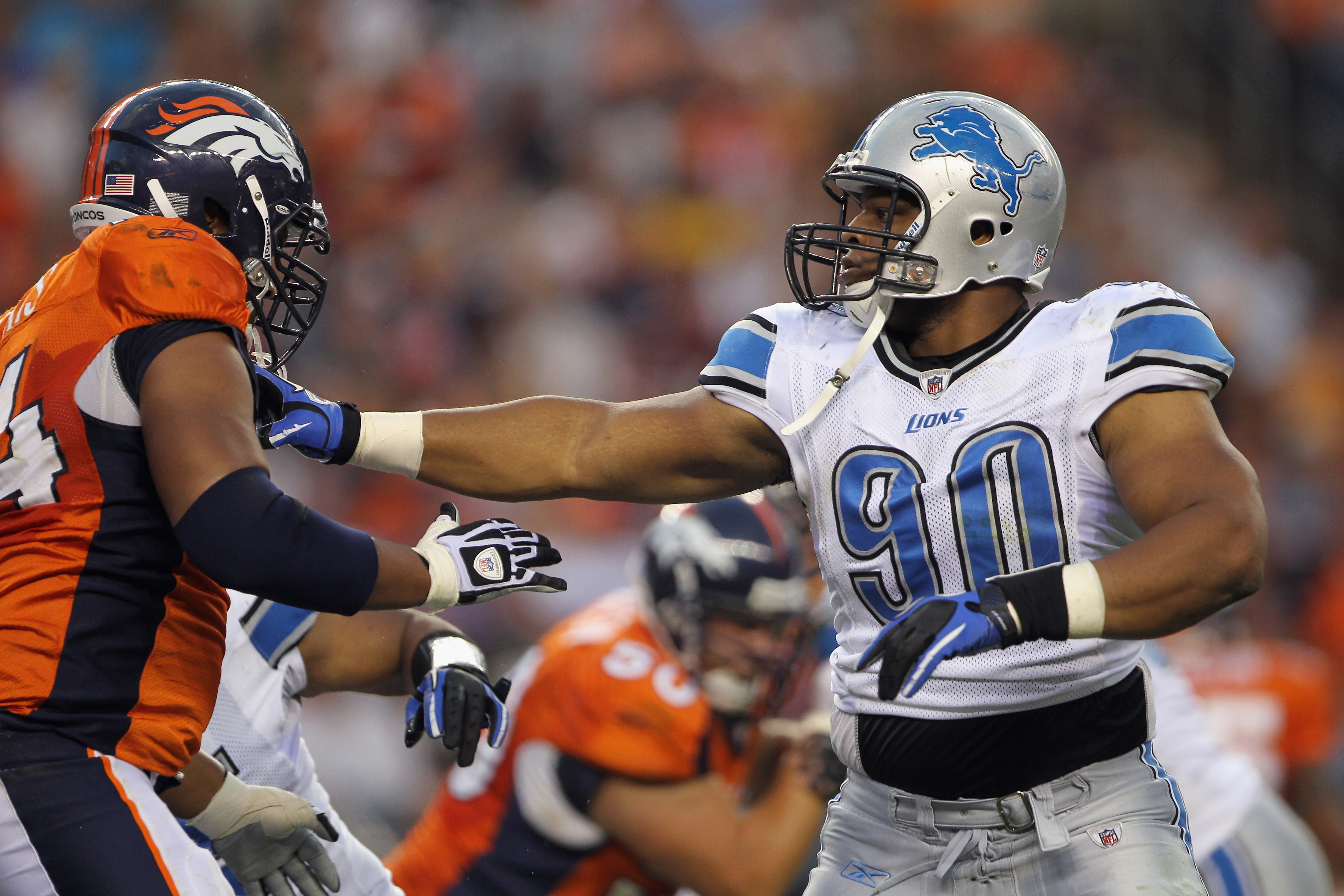 DENVER - AUGUST 21:  Defensive tackle Ndamukong Suh #90 of the Detroit Lions battles the blocking of offensive tackle Ryan Harris #74 of the Denver Broncos during preseason NFL action at INVESCO Field at Mile High on August 21, 2010 in Denver, Colorado. T