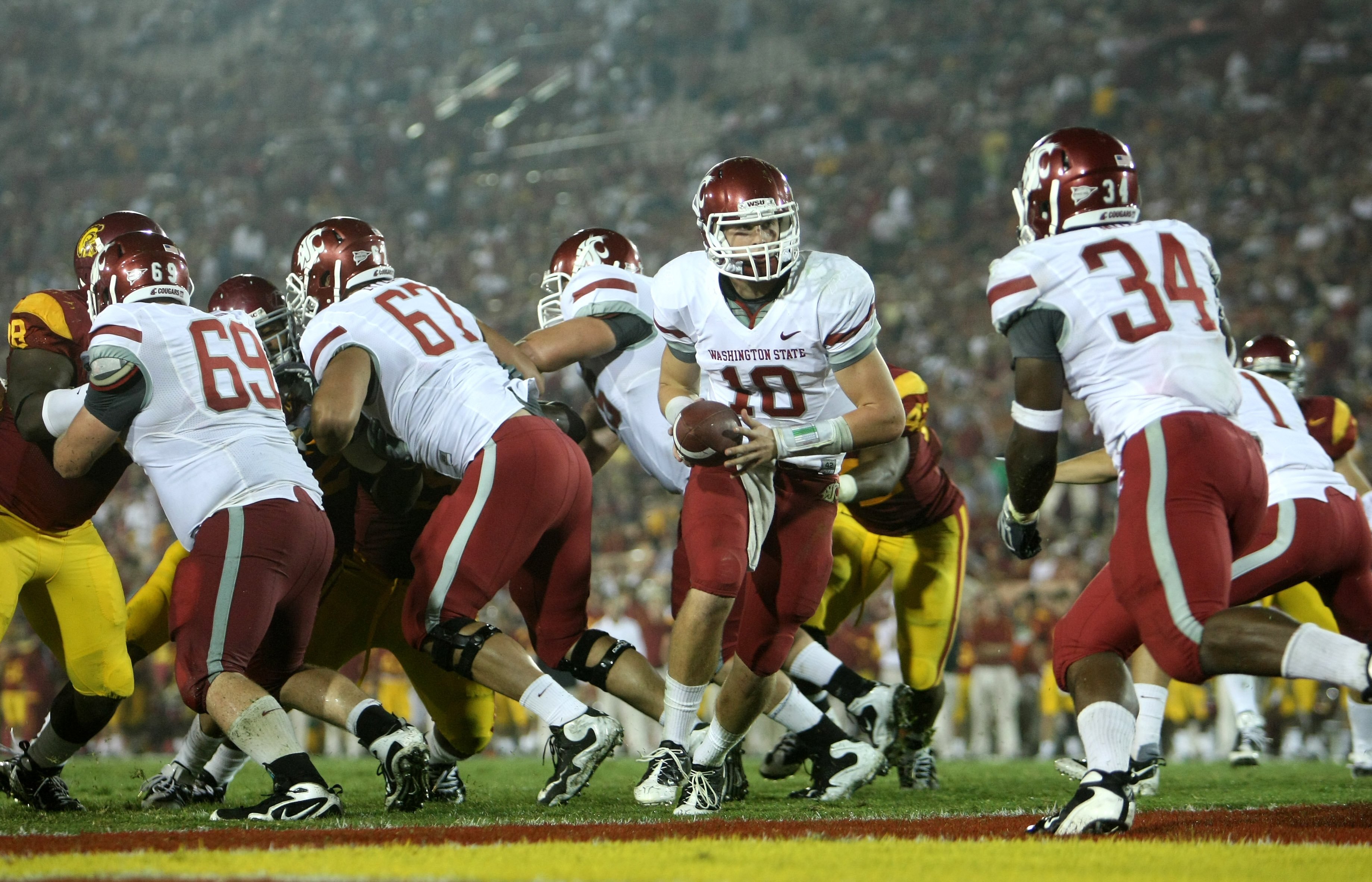 LOS ANGELES, CA - SEPTEMBER 26:  Quarterback Jeff Tuel #10 of the Washington State Cougars turns to hand off to running back Logwone Mitz #34 against the USC Trojans on September 23, 2009 at the Los Angeles Coliseum in Los Angeles, California.  USC won 27