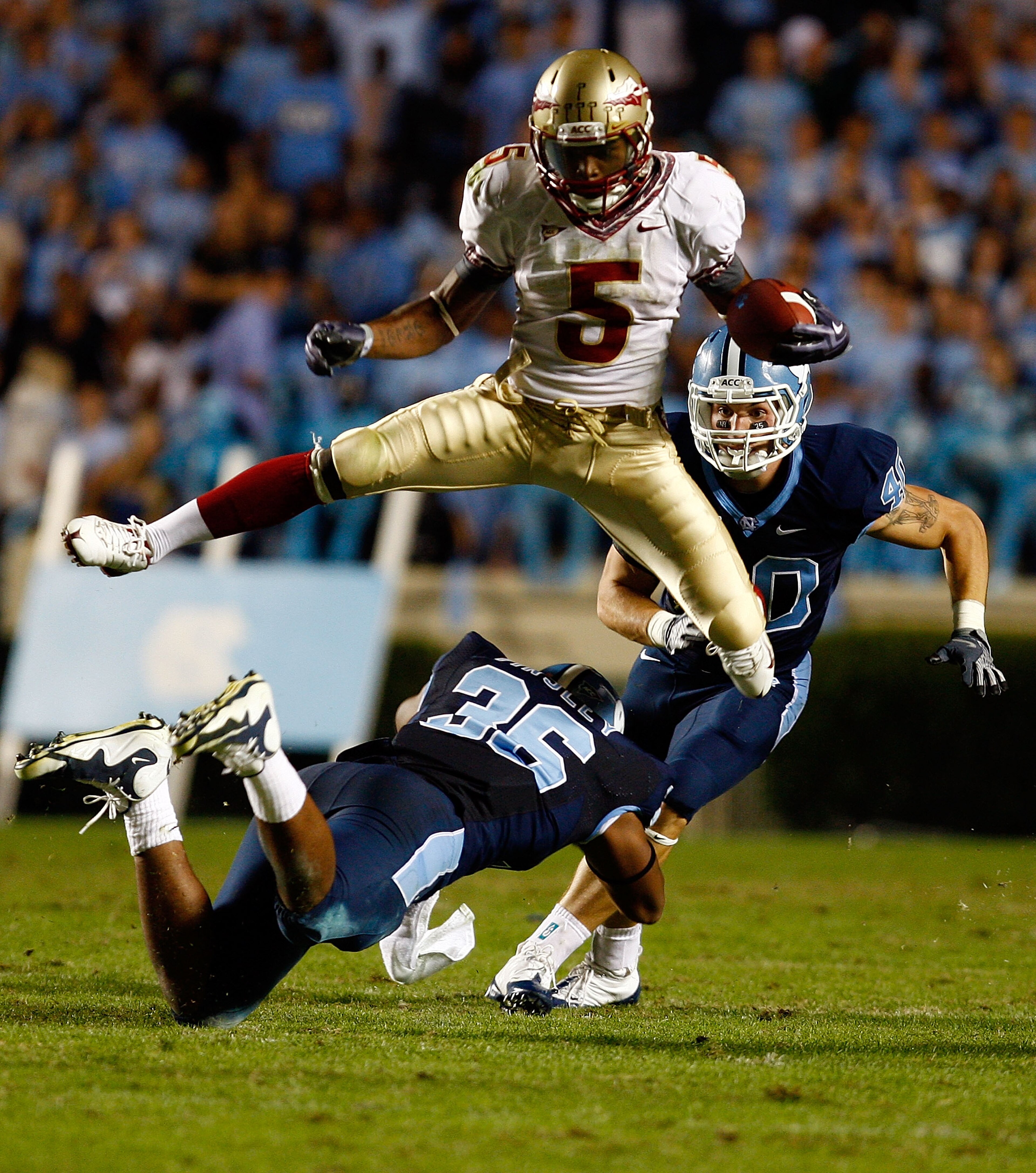 CHAPEL HILL, NC - OCTOBER 22: Greg Reid #5 of the Florida State Seminoles leaps over North Carolina Tar Heels defenders Kennedy Tinsley #36 and Hunter Furr, #40 at Kenan Stadium on October 22, 2009 in Chapel Hill, North Carolina. (Photo by Scott Hallera CHAPEL HILL, NC - OCTOBER 22: Greg Reid #5 of the Florida State Seminoles leaps over North Carolina Tar Heels defenders Kennedy Tinsley #36 and Hunter Furr, #40 at Kenan Stadium on October 22, 2009 in Chapel Hill, North Carolina. (Photo by Scott Hallera