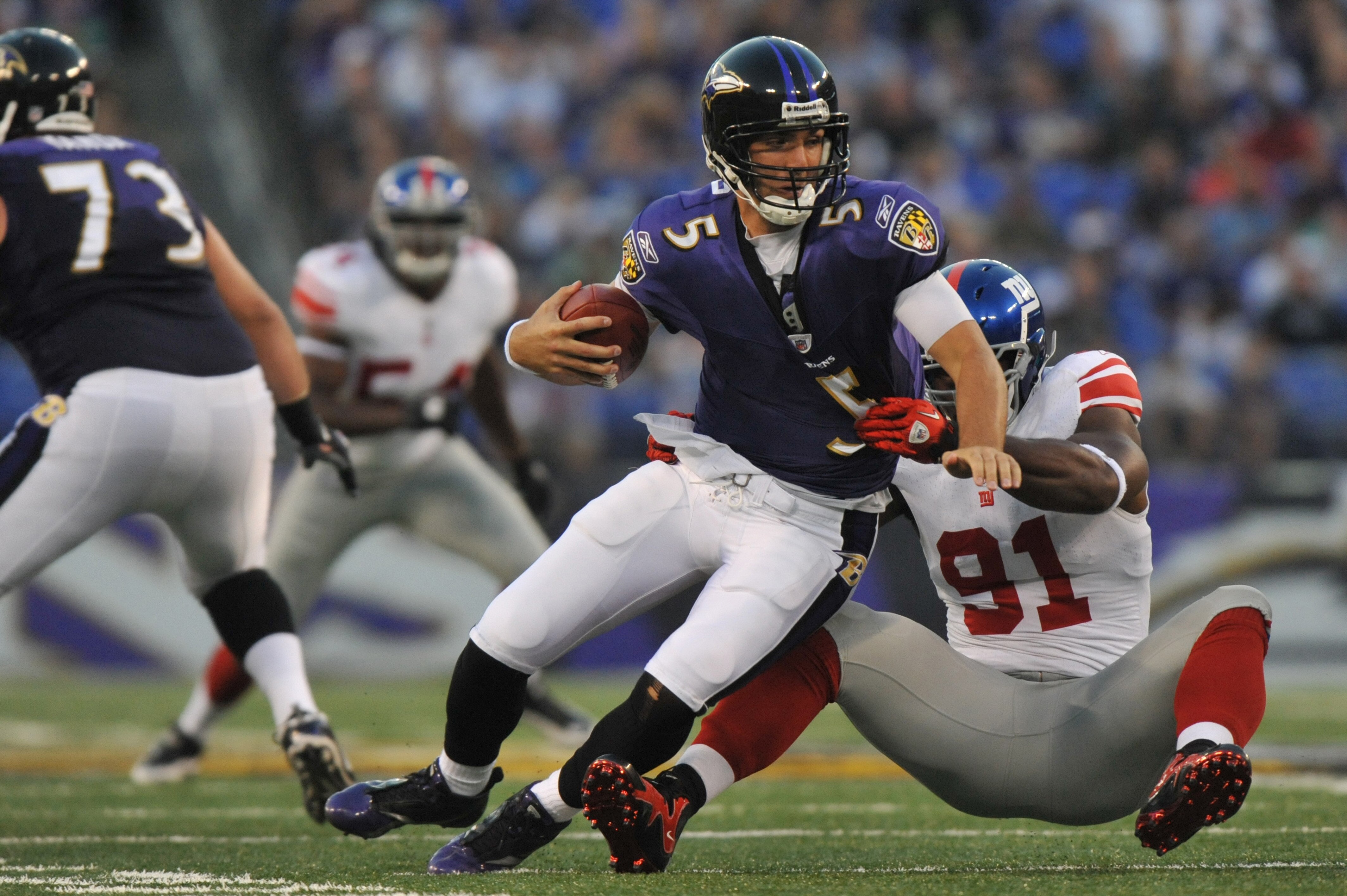 BALTIMORE - AUGUST 28:  Joe Flacco #5 of the Baltimore Ravens is sacked by Justin Tuck #91 the New York Giants at M&T Bank Stadium on August 28, 2010 in Baltimore, Maryland. The Ravens lead the Giants 17-3. (Photo by Larry French/Getty Images)
