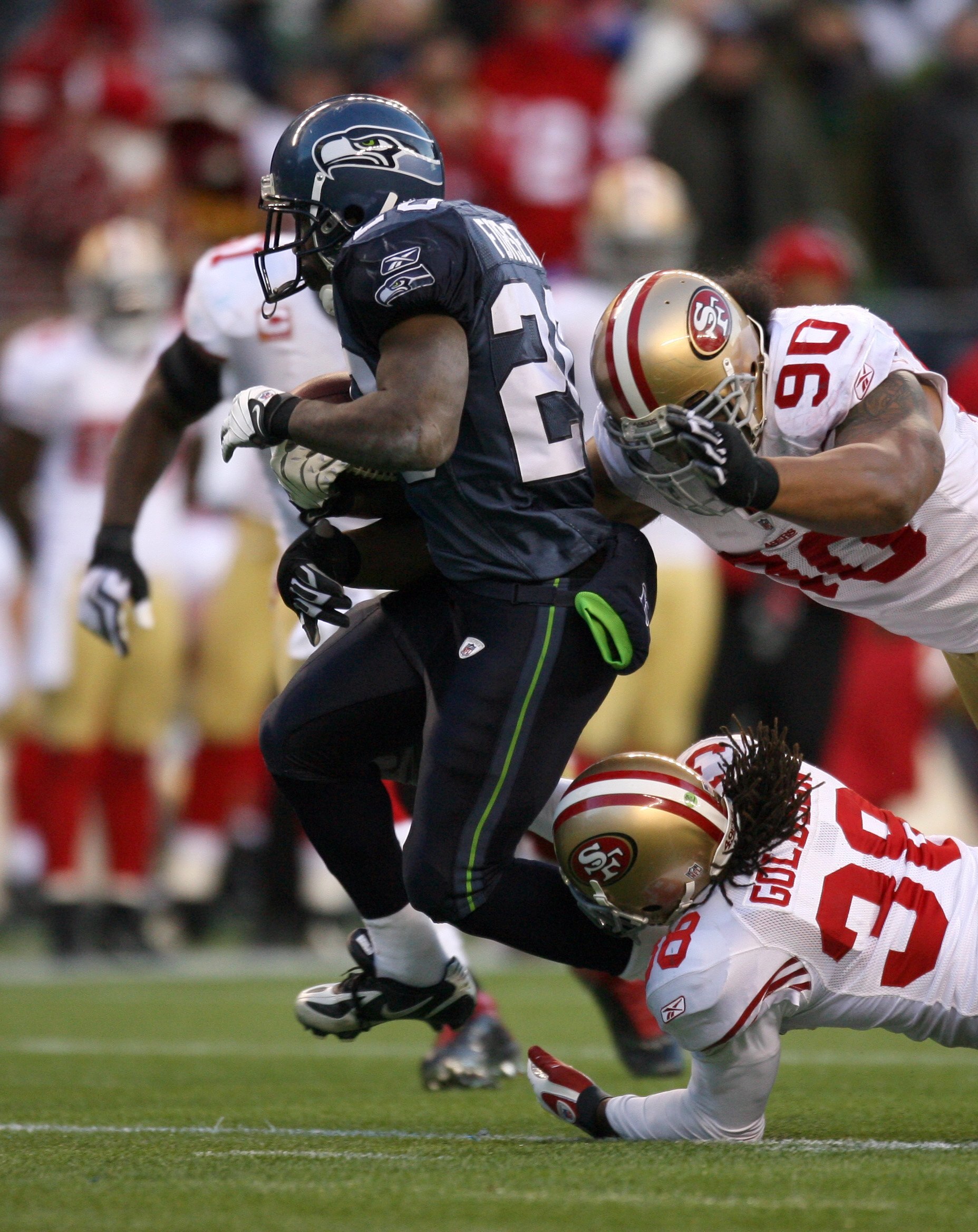 SEATTLE - DECEMBER 6:  Dashon Goldson #38 and Isaac Sopoaga #90 of the San Francisco 49ers gang tackle Justin Forsett #20 of the Seattle Seahawks during their NFL game on December 6, 2009 at Qwest Field in Seattle, Washington. The Seahawks defeated the 49