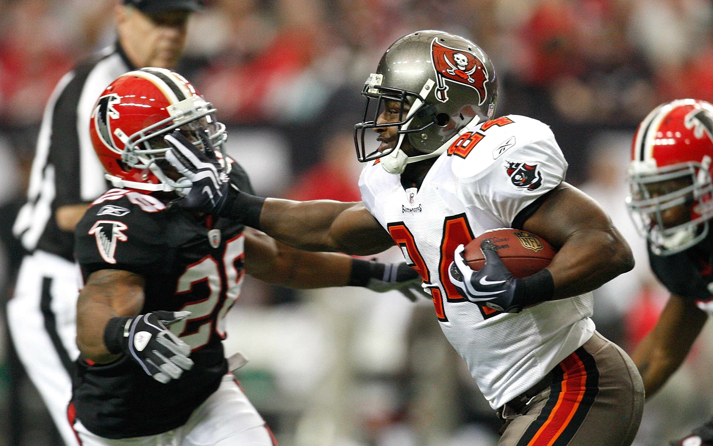 ATLANTA - NOVEMBER 29:  Cadillac Williams #24 of the Tampa Bay Buccaneers stiff arms Erik Coleman #26 of the Atlanta Falcons at Georgia Dome on November 29, 2009 in Atlanta, Georgia.  (Photo by Kevin C. Cox/Getty Images)