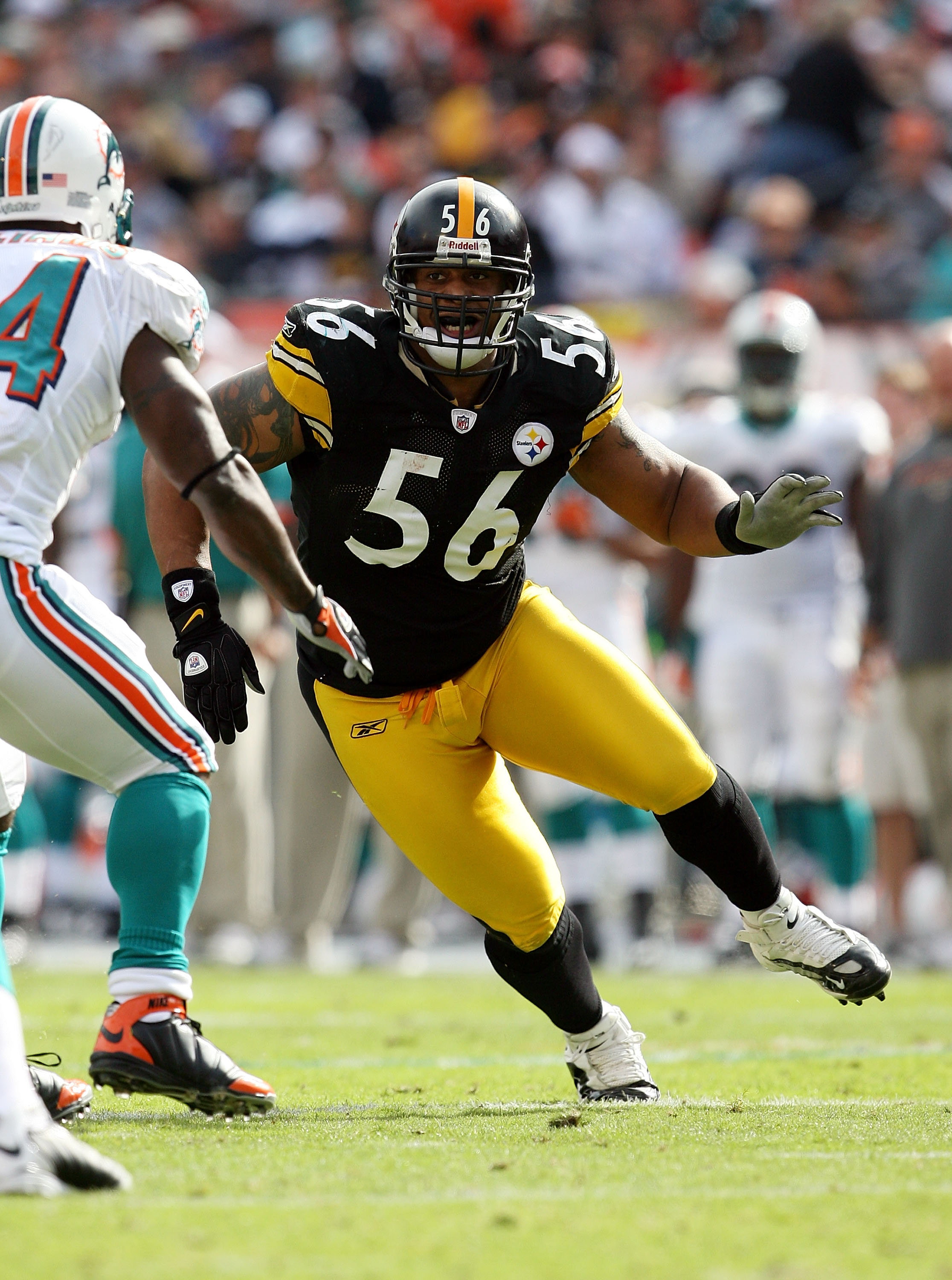 MIAMI - JANUARY 03:  Linebacker LaMarr Woodley #56 of the Pittsburgh Steelers tries to get into the backfield around running back Ricky Williams #34 of the Miami Dolphins at Land Shark Stadium on January 3, 2010 in Miami, Florida. The Steelers defeated th