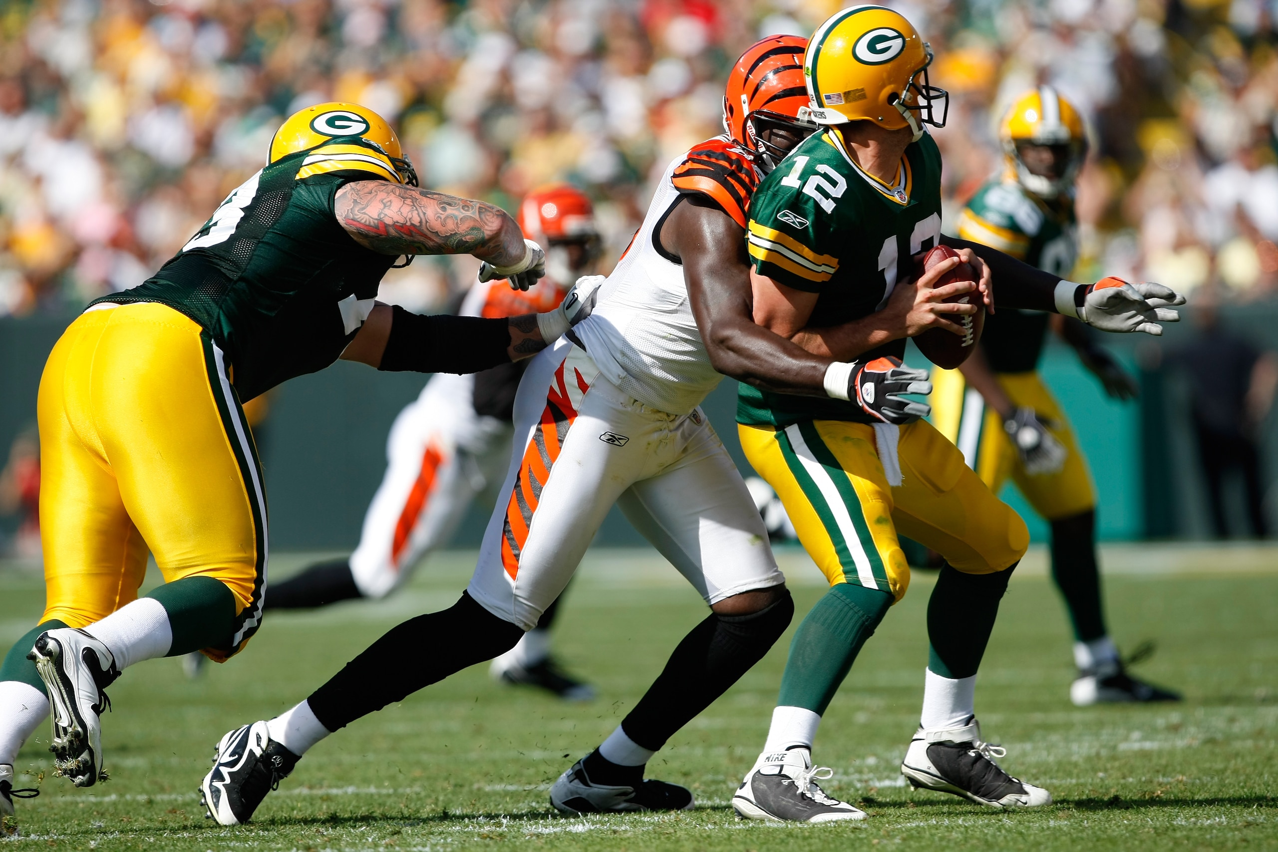 GREEN BAY, WI - SEPTEMBER 20: Quarterback Aaron Rogers #12 of the Green Bay Packers is sacked by defensive end Antwan Odem #98 of the Cincinnati Bengals at Lambeau Field on September 20, 2009 in Green Bay, Wisconsin. The Bengals defeated the Packers 31-24