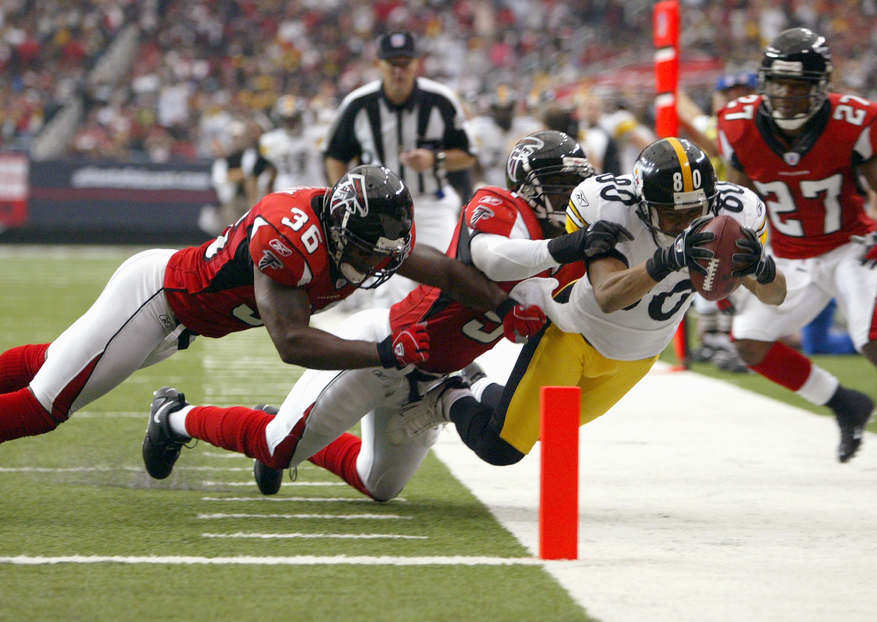 ATLANTA - OCTOBER 22: Cedrick Wilson #80 of the Pittsburgh Steelers leaps for the goal line against lawyer Milloy #36 of the Atlanta Falcons on October 22, 2006 at the Georgia Dome in Atlanta, Georgia. (Photo by Doug Pensinger/Getty Images)