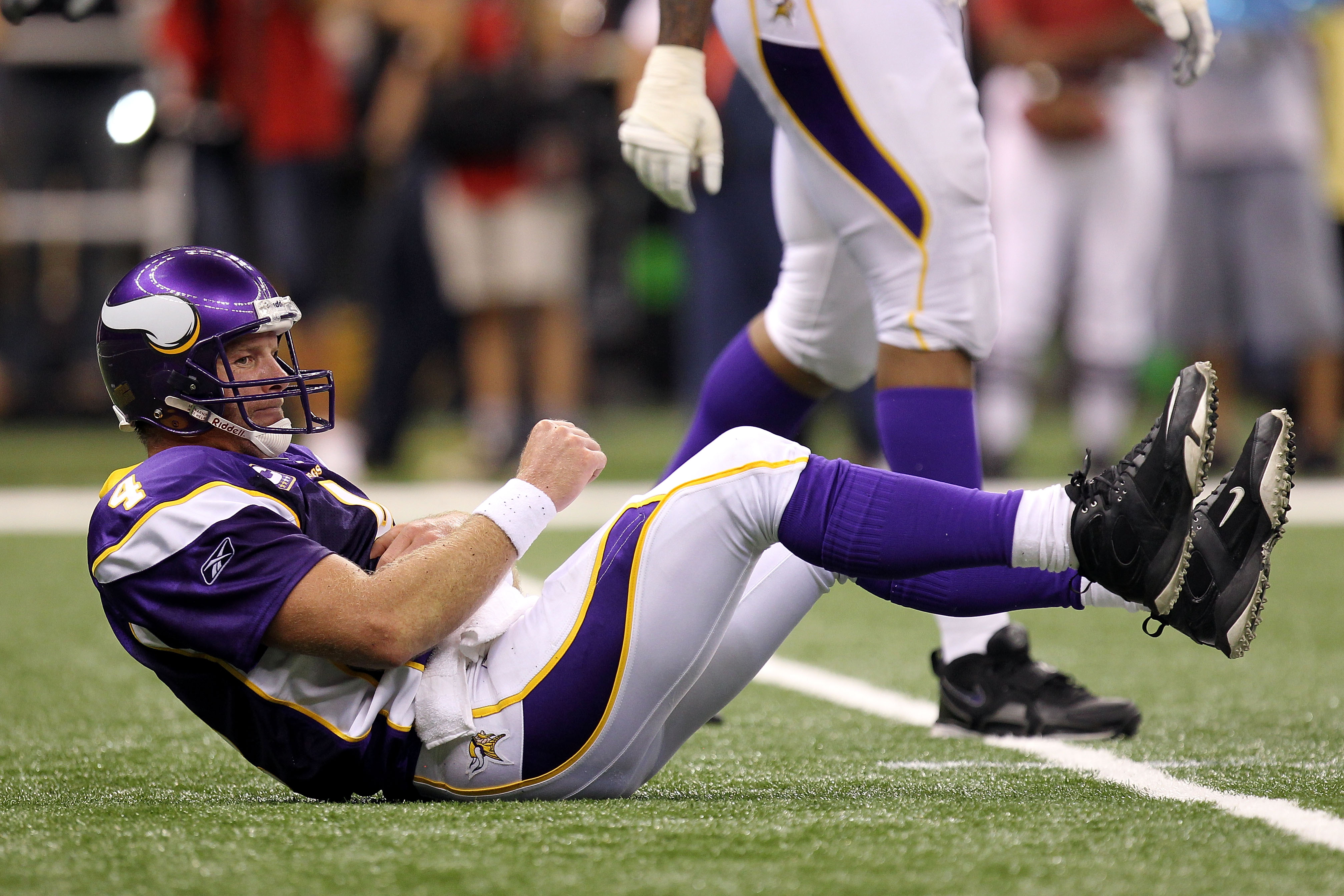 NEW ORLEANS - SEPTEMBER 09: Quarterback Brett Favre #4 of the Minnesota Vikings grabs his torso as he lies on the turf after taking a hard hit from Roman Harper #41 of the New Orleans Saints at Louisiana Superdome on September 9, 2010 in New Orleans, Lou NEW ORLEANS - SEPTEMBER 09: Quarterback Brett Favre #4 of the Minnesota Vikings grabs his torso as he lies on the turf after taking a hard hit from Roman Harper #41 of the New Orleans Saints at Louisiana Superdome on September 9, 2010 in New Orleans, Lou