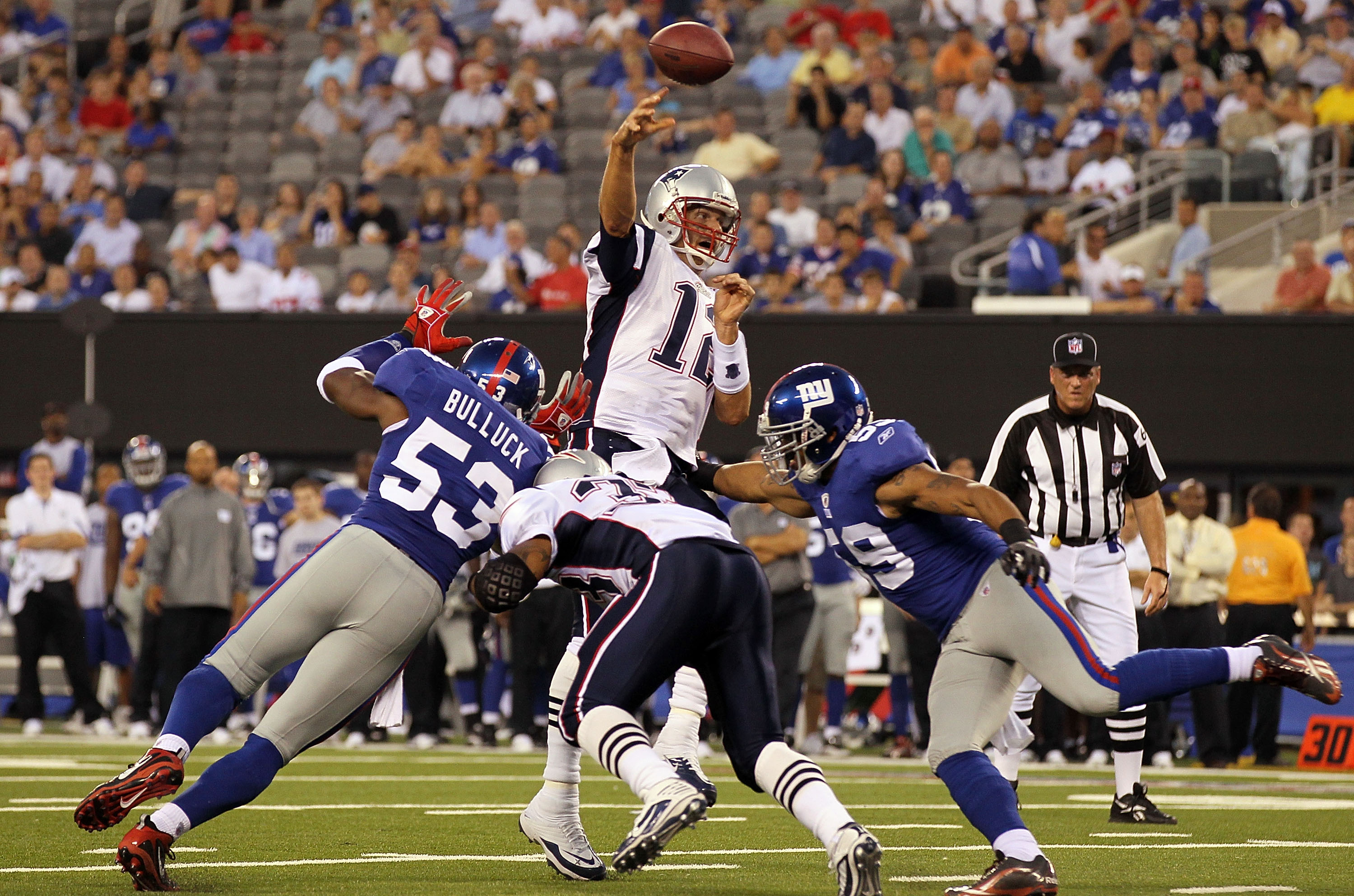 EAST RUTHERFORD, NJ - SEPTEMBER 02:  Tom Brady #12 of the New England Patriots throws a touchdown pass in the first quarter against the New York Giants to teammate Rob Gronkowski  (not pictured) on September 2, 2010 at the New Meadowlands Stadium in East