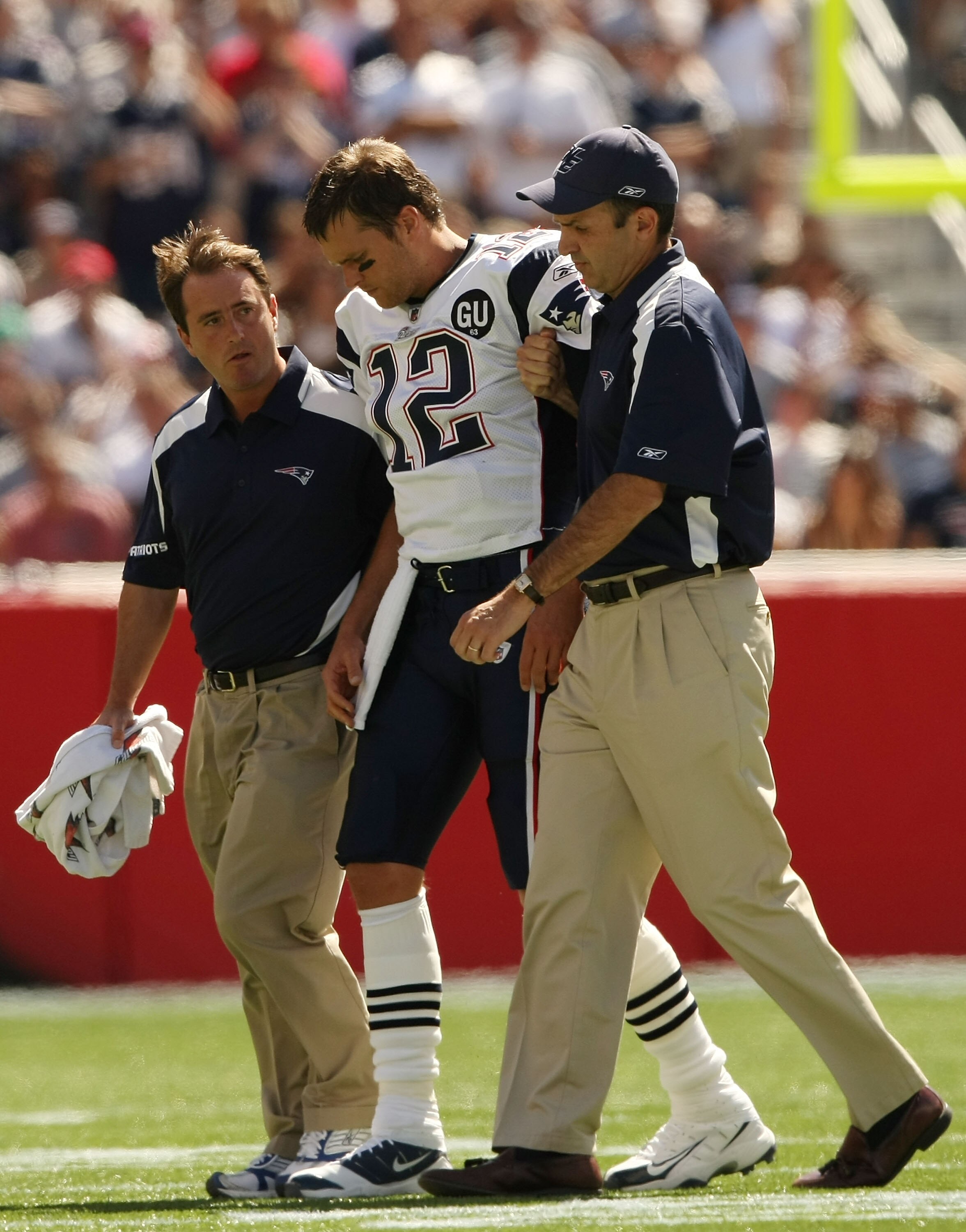FOXBORO, MA - SEPTEMBER 7:  Quarterback Tom Brady #12 of the New England Patriots is helped off the field by trainers after he sustained an injury to his left knee in the first quarter against the Kansas City Chiefs at Gillette Stadium September 7, 2008 i