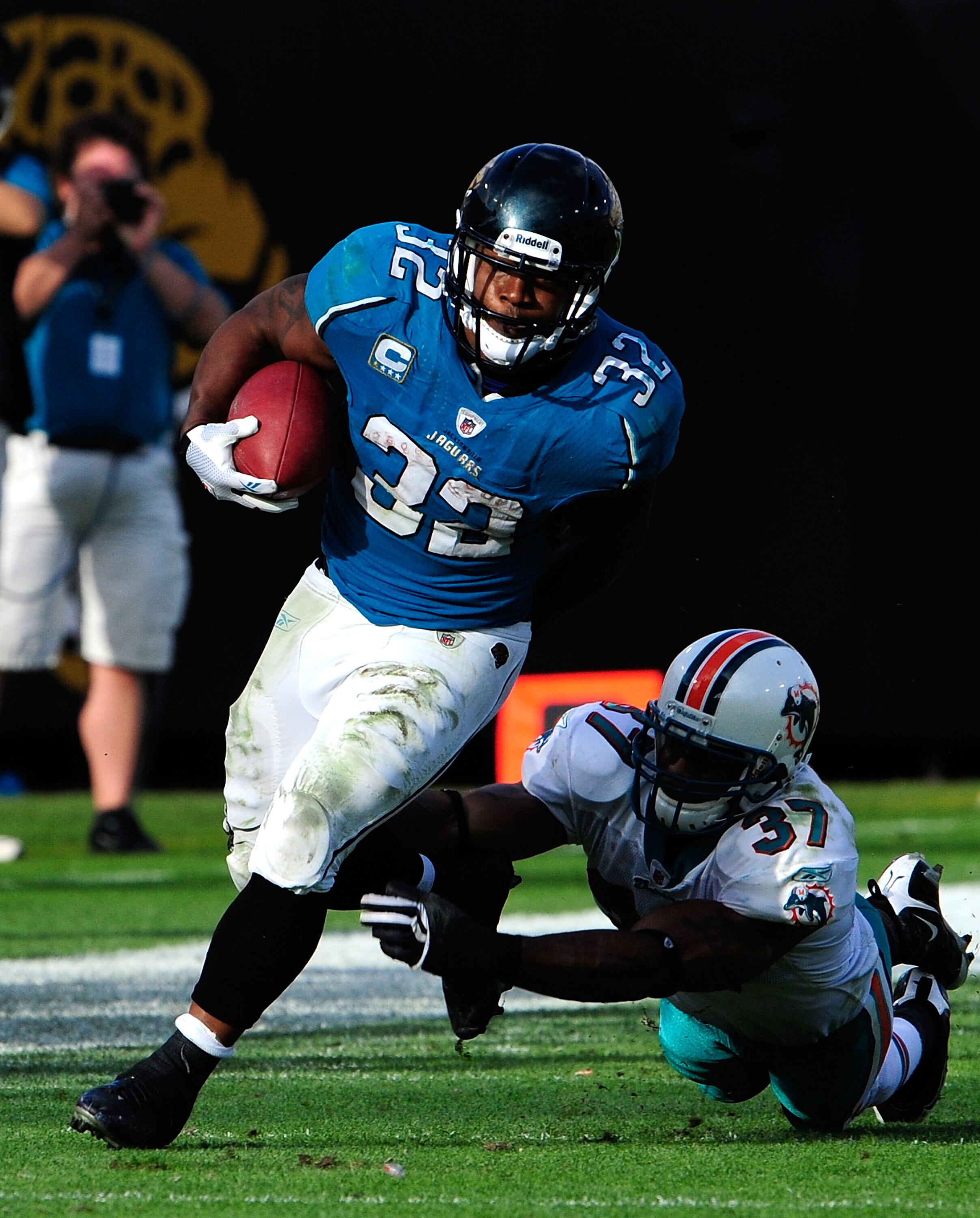 JACKSONVILLE, FL - DECEMBER 13:  Maurice Jones-Drew #32 of the Jacksonville Jaguars runs the ball against Yeremiah Bell #37 of the Miami Dolphins during the game at Jacksonville Municipal Stadium on December 13, 2009 in Jacksonville, Florida.  The Dolphin