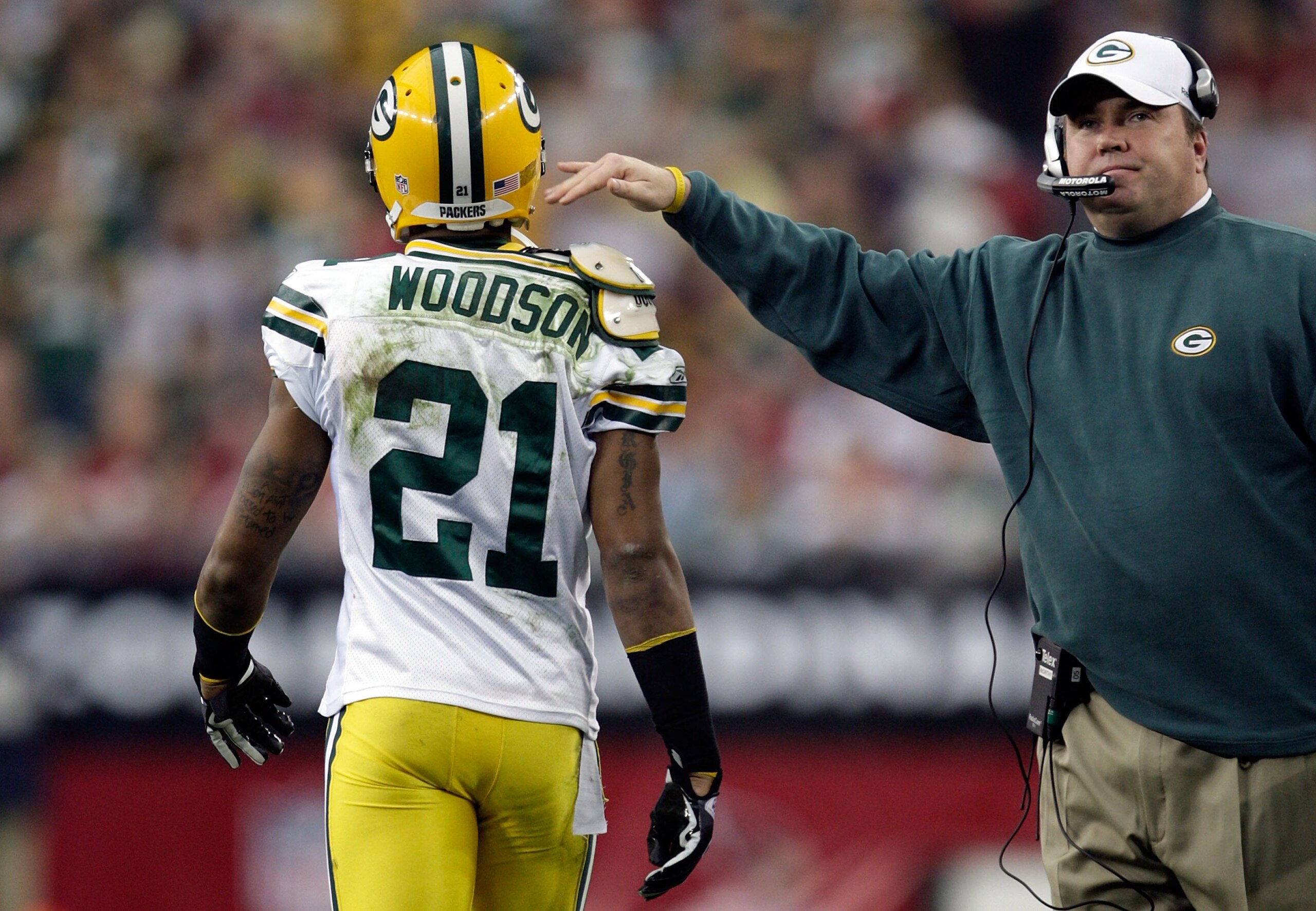 GLENDALE, AZ - JANUARY 03:  (R-L) Head coach Mike McCarthy of the Green Bay Packers pats Charles Woodson #21 on the back against the Arizona Cardinals at University of Phoenix Stadium on January 3, 2010 in Glendale, Arizona.  (Photo by Jamie Squire/Getty 