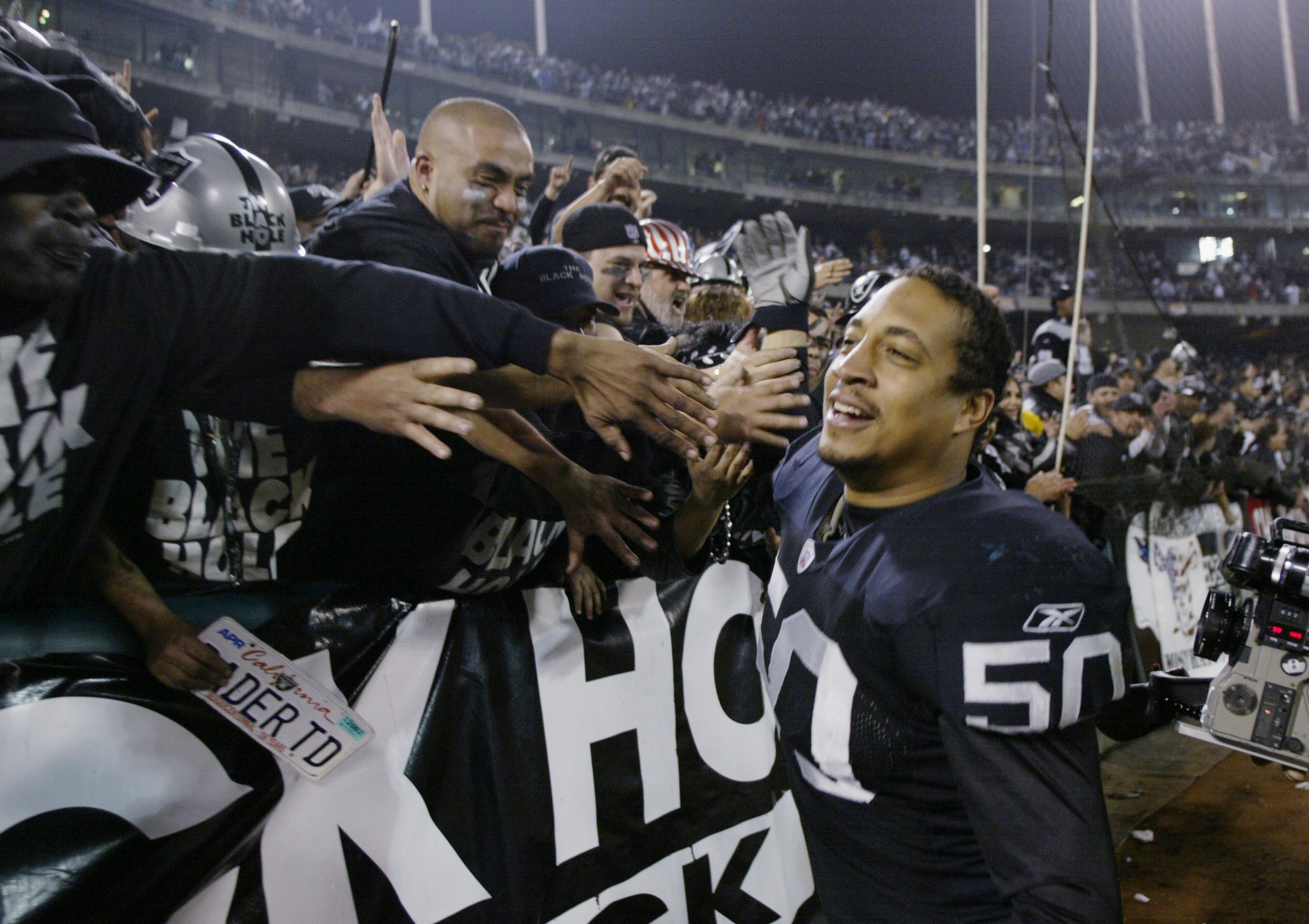 OAKLAND, CA - JANUARY 19:  Linebacker Eric Barton #50 of the Oakland Raiders celebrates with fans in the Black Hole after the 41-24 victory over the Tennessee Titans in the AFC Championship game at Network Associates Coliseum on January 19, 2003 in Oaklan
