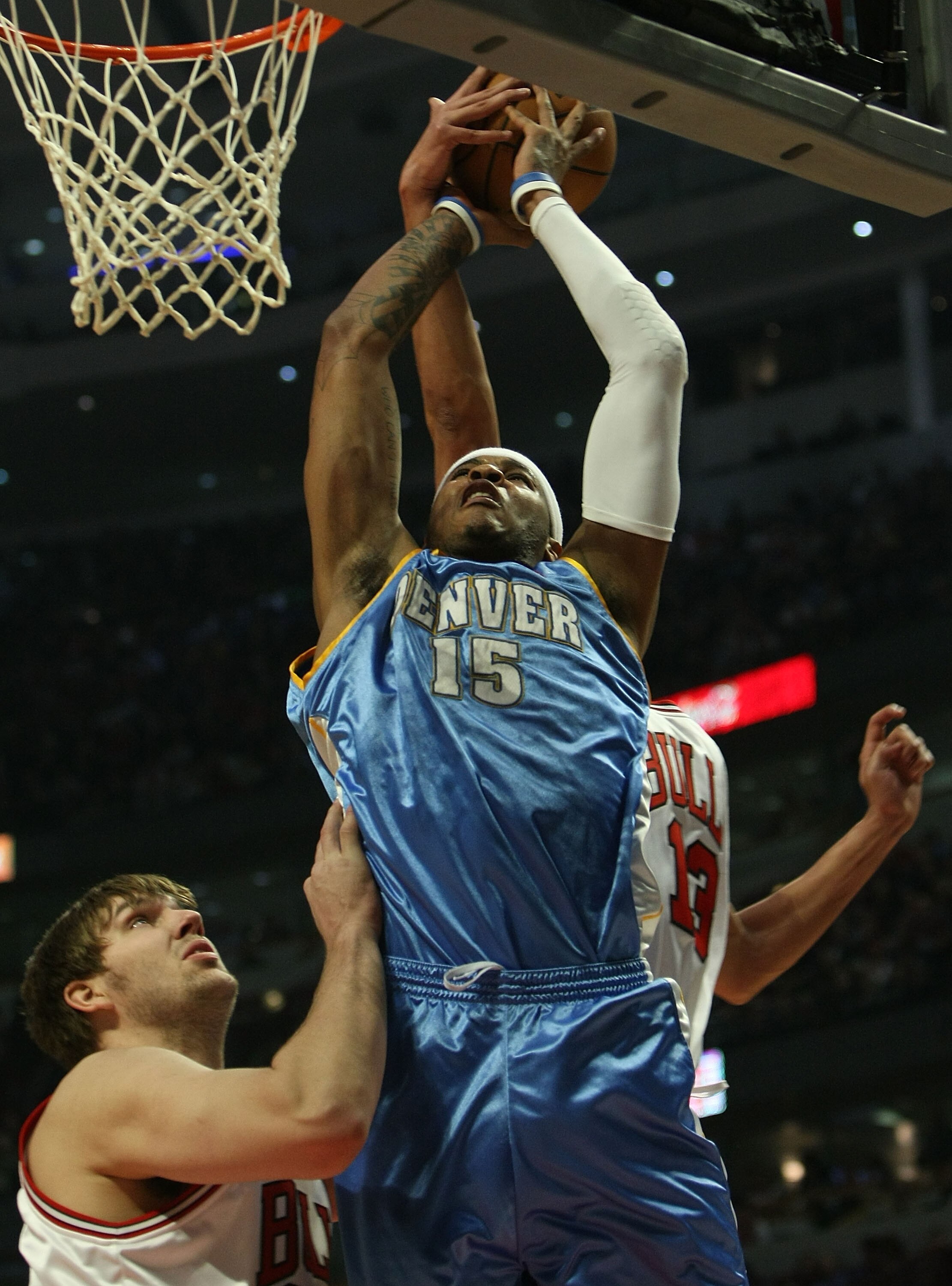 CHICAGO - FEBRUARY 22: Joakim Noah #13 of the Chicago Bulls (rear) blocks a shot by Carmelo Anthony #15 of the Denver Nuggets as teammate Aaron Gray #34 defends below on February 22, 2008 at the United Center in Chicago, Illinois. NOTE TO USER: User expre