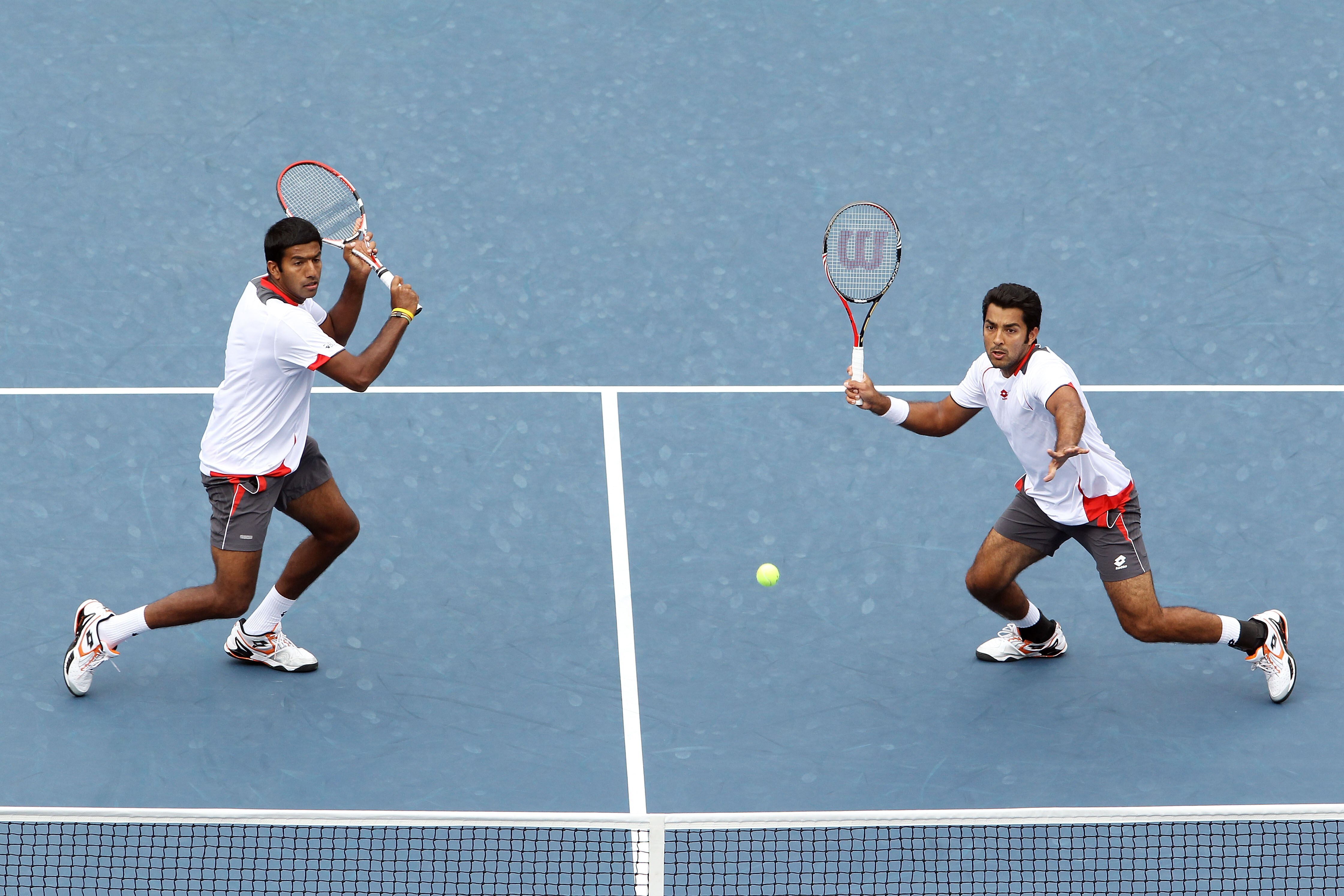 NEW YORK - SEPTEMBER 10:  Aisam-Ul-Haq Qureshi of Pakistan (R) returns a shot with Rohan Bopanna of India against Bob Bryan of the United States and Mike Bryan of the United States during the men's doubles final on day twelve of the 2010 U.S. Open at the 