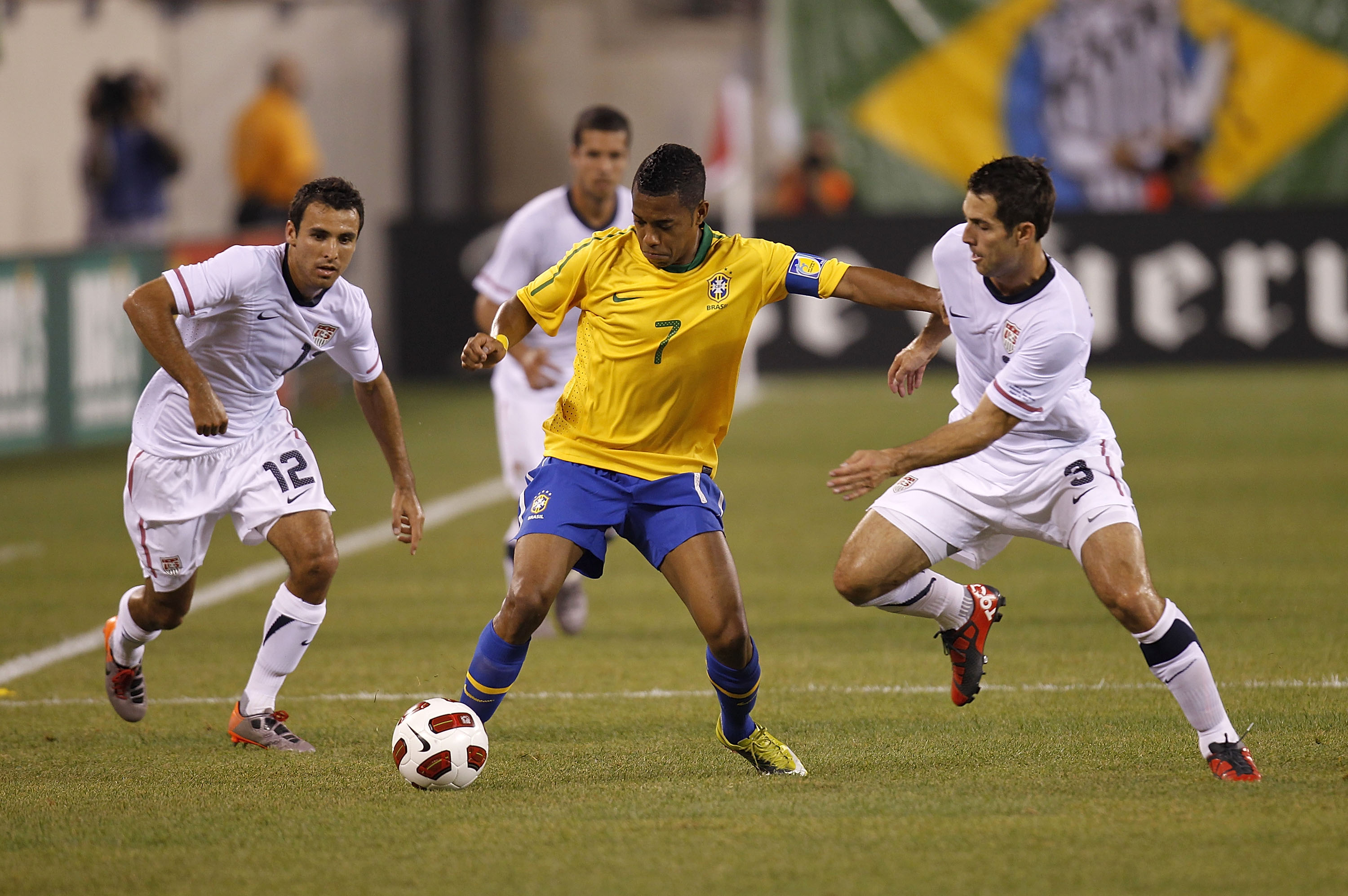 EAST RUTHERFORD, NJ - AUGUST 10: Jonathan Bornstein #12 and Carlos Bocanegra #3 of the U.S. guard Robinho #7 of Brazil in the first half of a friendly match at the New Meadowlands on August 10, 2010 in East Rutherford, New Jersey. (Photo by Jeff Zelevansk