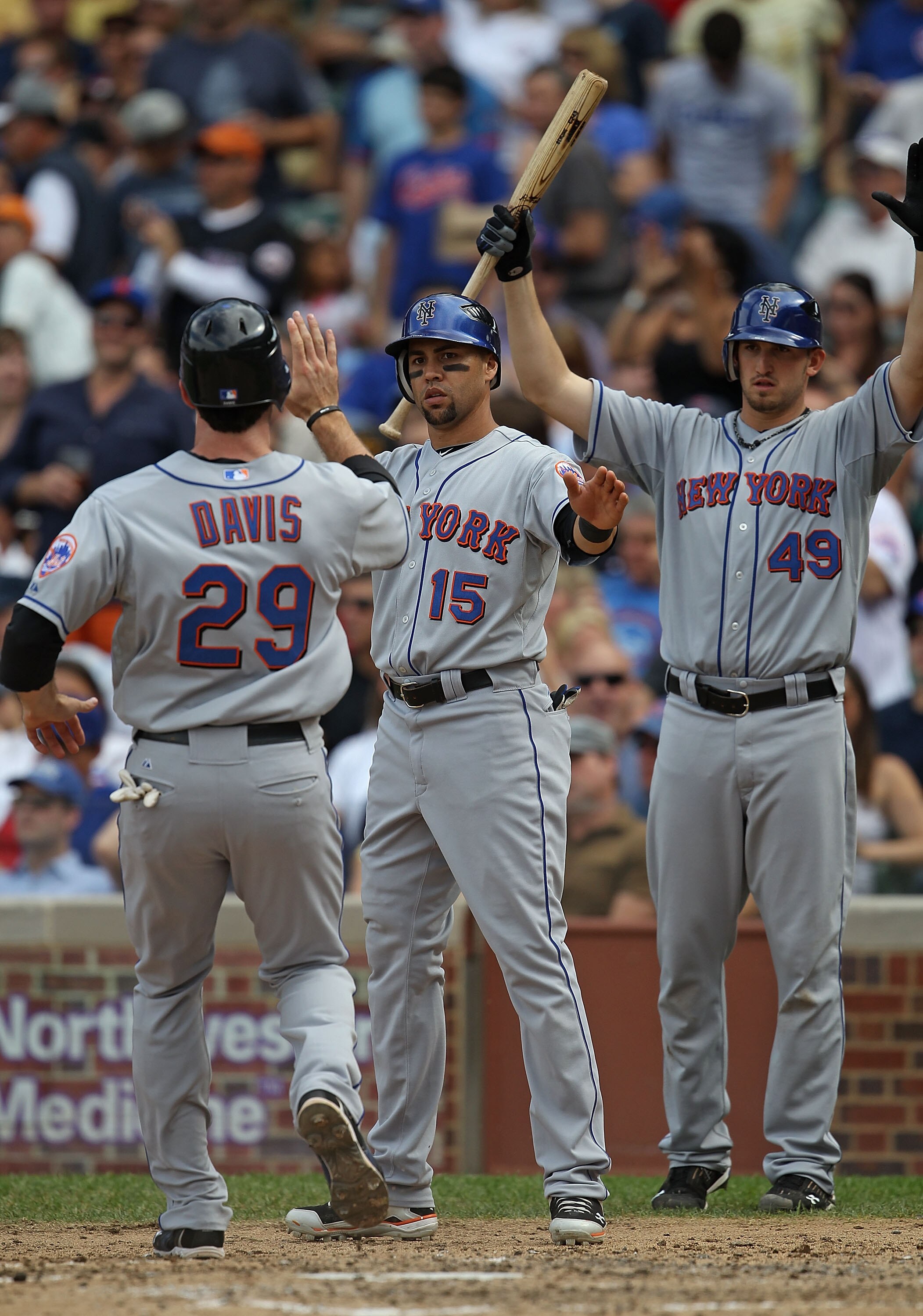 CHICAGO - SEPTEMBER 05: Carlos Beltran #15 and Jonathan Niese #49 of the New York Mets greet teammate Ike Davis #29 after Beltran and Davis scored runs against the Chicago Cubs in the 5th inning at Wrigley Field on September 5, 2010 in Chicago, Illinois.