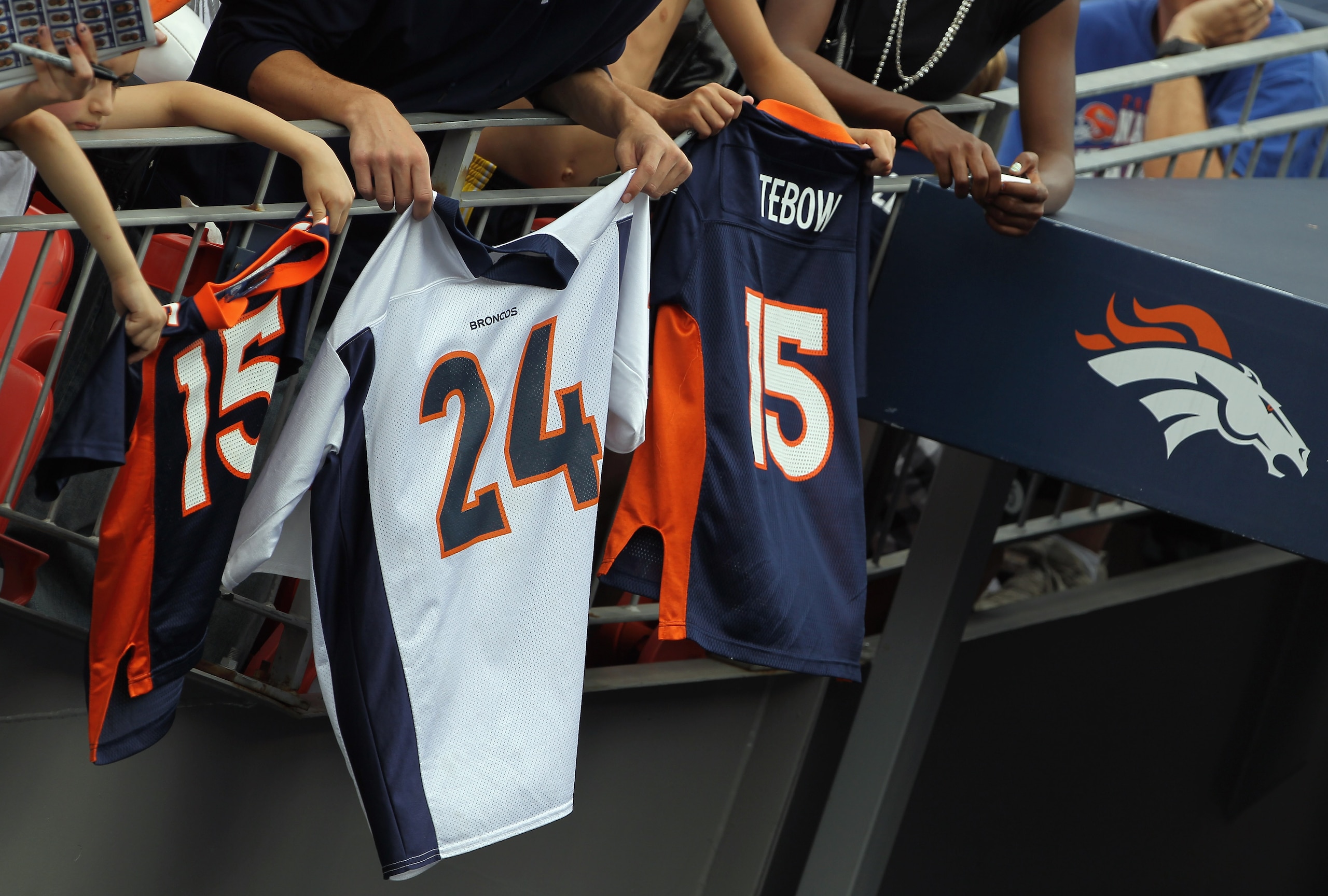 DENVER - AUGUST 21: Bronco fans dangle jerseys of Champ Bailey and Tim Tebow into the tunnel entrance to the field hoping for an autograph prior to the game as the Denver Broncos host the Detroit Lions during preseason NFL action at INVESCO Field at Mile DENVER - AUGUST 21: Bronco fans dangle jerseys of Champ Bailey and Tim Tebow into the tunnel entrance to the field hoping for an autograph prior to the game as the Denver Broncos host the Detroit Lions during preseason NFL action at INVESCO Field at Mile