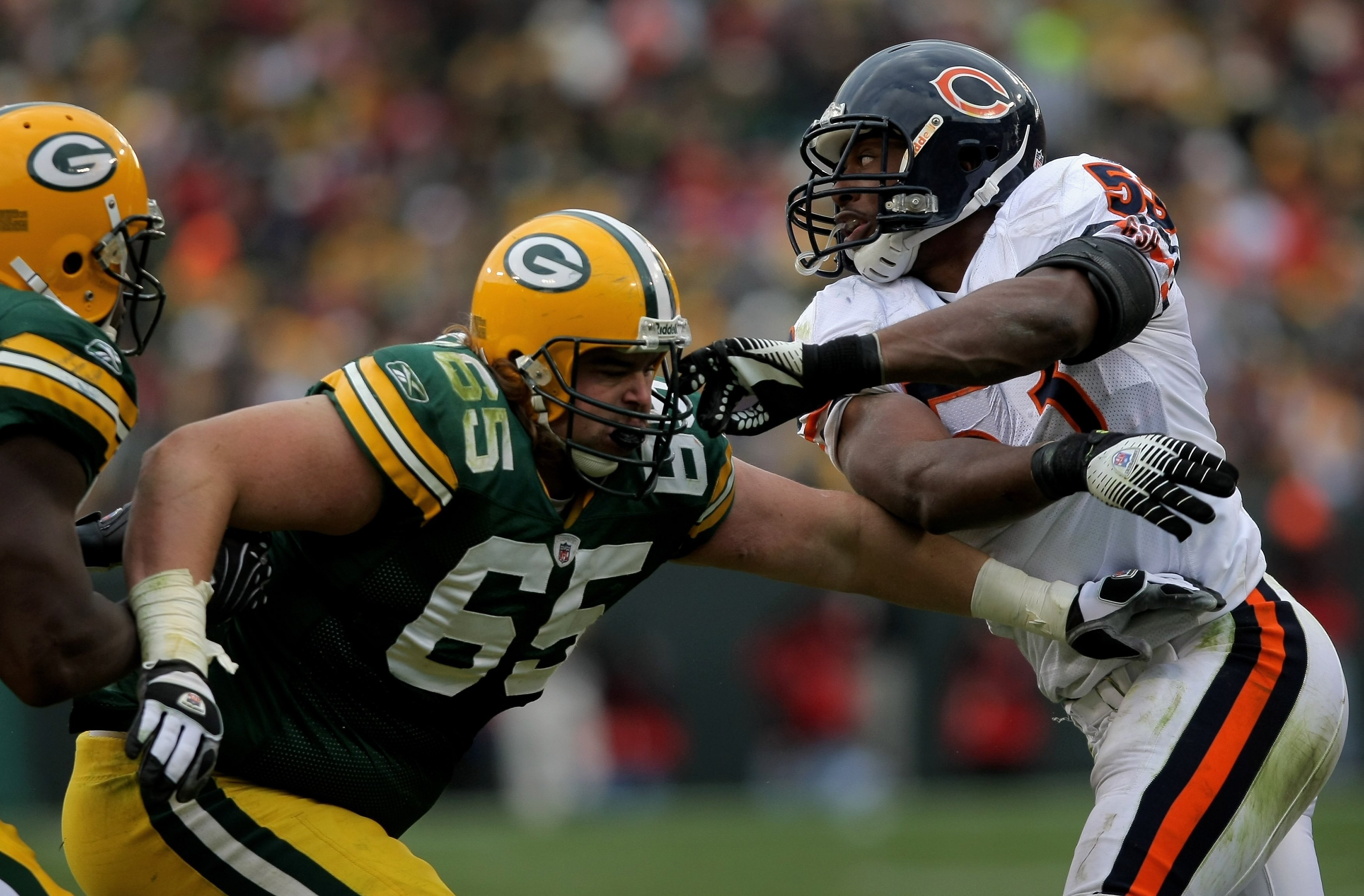GREEN BAY, WI - NOVEMBER 16:  Linebacker Nick Roach #53 of the Chicago Bears tries to elude the block of offensive tackle Mark Tauscher #65 of the Green Bay Packers during NFL action at Lambeau Field on November 16, 2008 in Green Bay, Wisconsin. The Packe