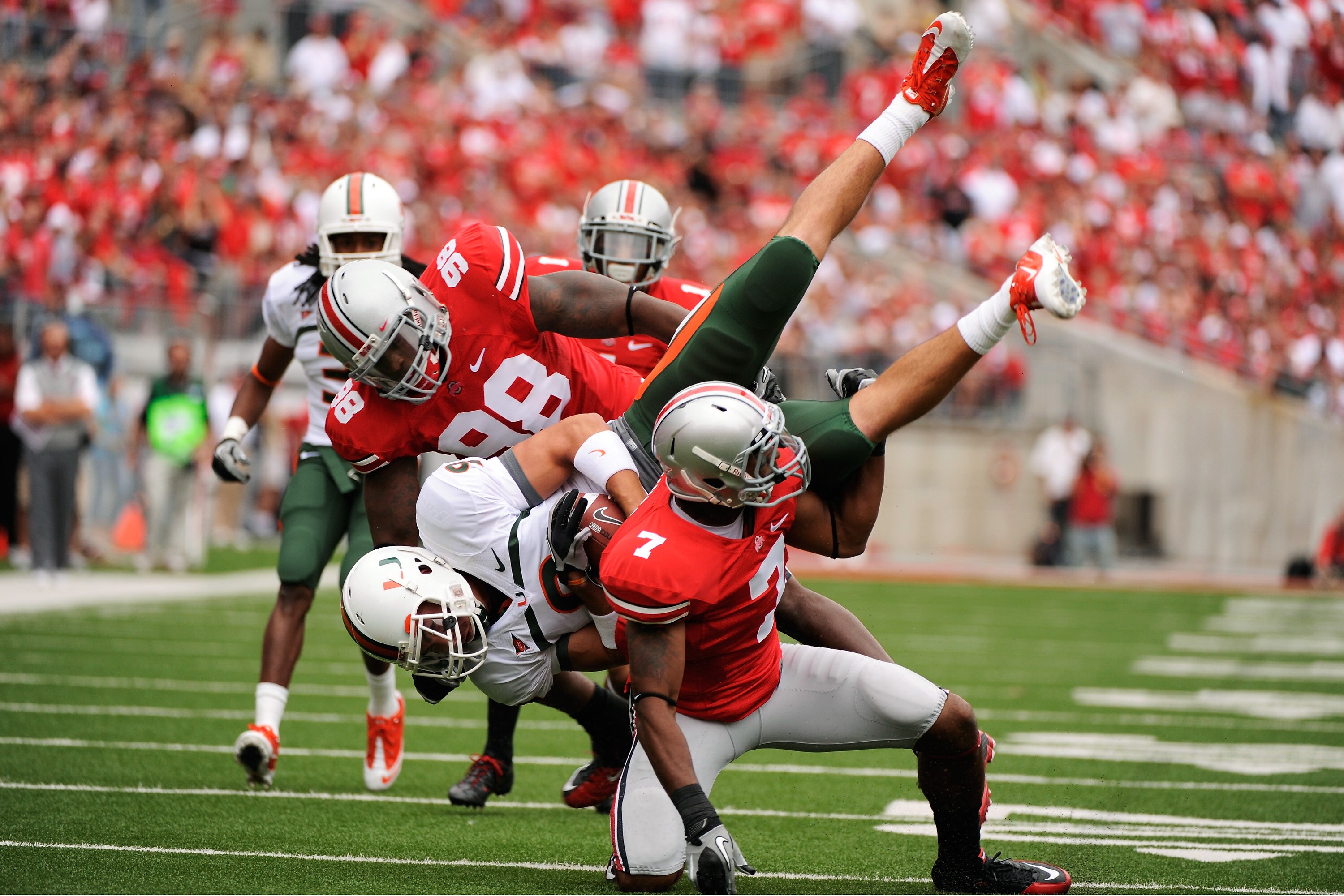 COLUMBUS, OH - SEPTEMBER 11:  Chase Ford #9 of the Miami Hurricanes is upended by Solomon Thomas #98 of the Ohio State Buckeyes and Jermale Hines #7 of the Ohio State Buckeyes at Ohio Stadium on September 11, 2010 in Columbus, Ohio.  (Photo by Jamie Sabau