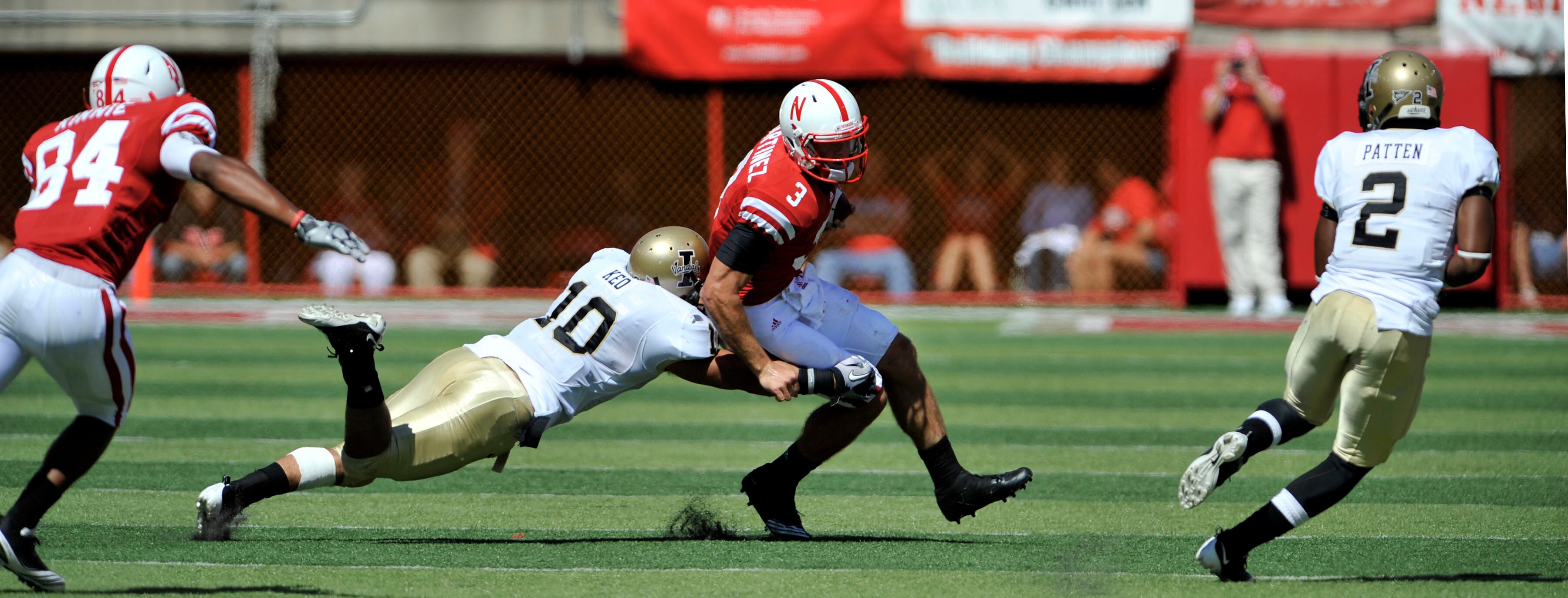 LINCOLN, NE - SEPTEMBER 11: Nebraska Cornhuskers quarterback Taylor Martinez #3 runs from Idaho Vandals safety Shiloh Keo #10 and Idaho Vandals cornerback Kenneth Patten #2 during second half action of their game at Memorial Stadium on September 4, 2010 i