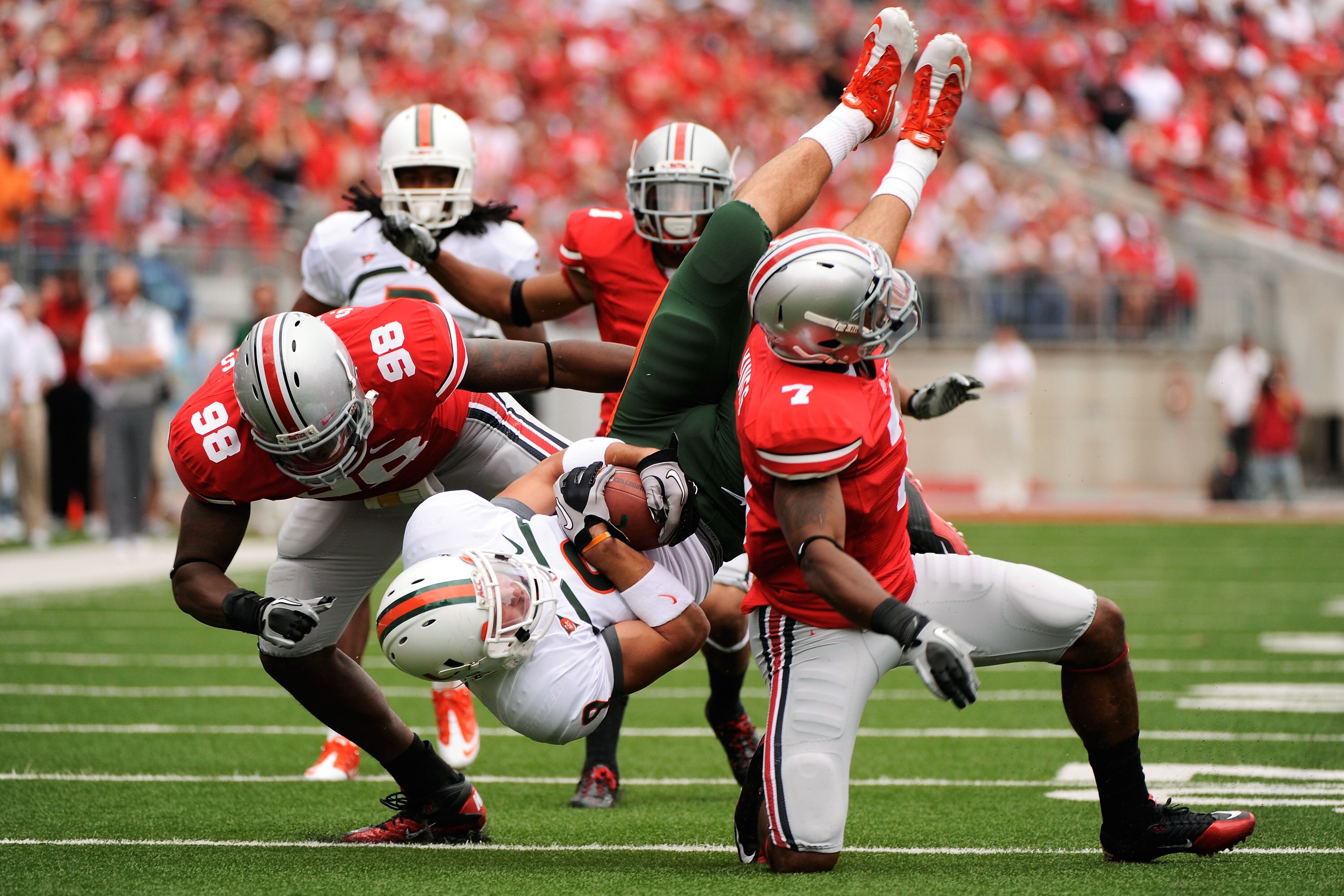 COLUMBUS, OH - SEPTEMBER 11:  Chase Ford #9 of the Miami Hurricanes is upended by Solomon Thomas #98 of the Ohio State Buckeyes and Jermale Hines #7 of the Ohio State Buckeyes at Ohio Stadium on September 11, 2010 in Columbus, Ohio.  (Photo by Jamie Sabau