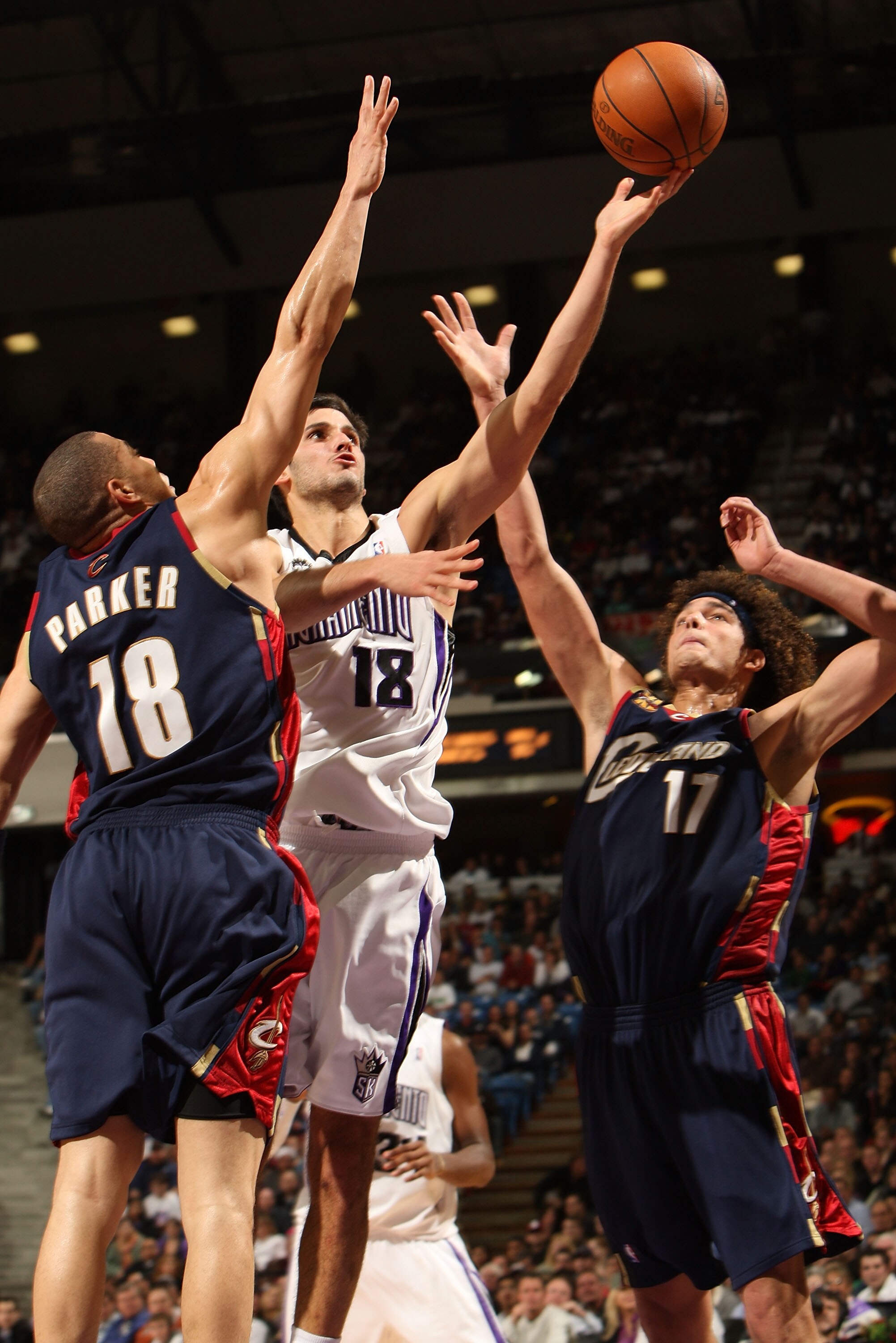 SACRAMENTO, CA - DECEMBER 23:  Omri Casspi #18 of the Sacramento Kings shoots against Anthony Parker #18 and Andrew Varejao #17 of the Cleveland Cavaliers during an NBA game at ARCO Arena on December 23, 2009 in Sacramento, California.  NOTE TO USER: User