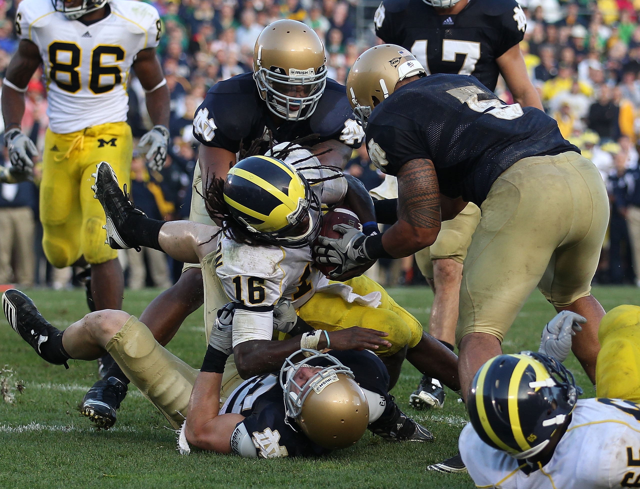 SOUTH BEND, IN - SEPTEMBER 11: Denard Robinson #16 of the Michigan Wolverines dives into the end zone for the game-winning touchdown as Harrison Smith #22 of the Notre Dame Fighting Irish brings him down while Manti Te'o #5 tries to grab the ball at Notre