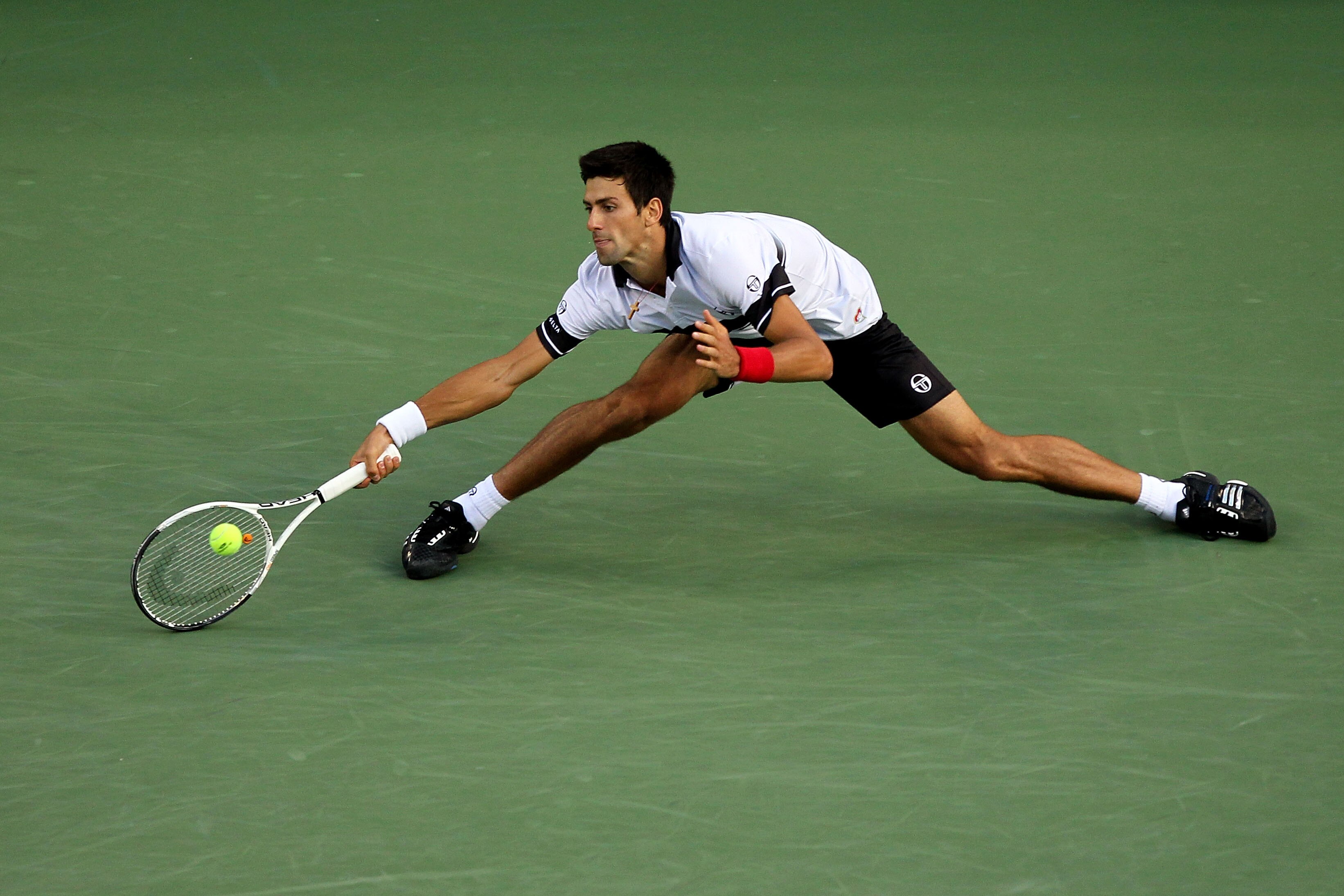 NEW YORK - SEPTEMBER 11: Novak Djokovic of Serbia returns a shot against Roger Federer of Switzerland during his men's singles semifinal match on day thirteen of the 2010 U.S. Open at the USTA Billie Jean King National Tennis Center on September 11, 2010 NEW YORK - SEPTEMBER 11: Novak Djokovic of Serbia returns a shot against Roger Federer of Switzerland during his men's singles semifinal match on day thirteen of the 2010 U.S. Open at the USTA Billie Jean King National Tennis Center on September 11, 2010