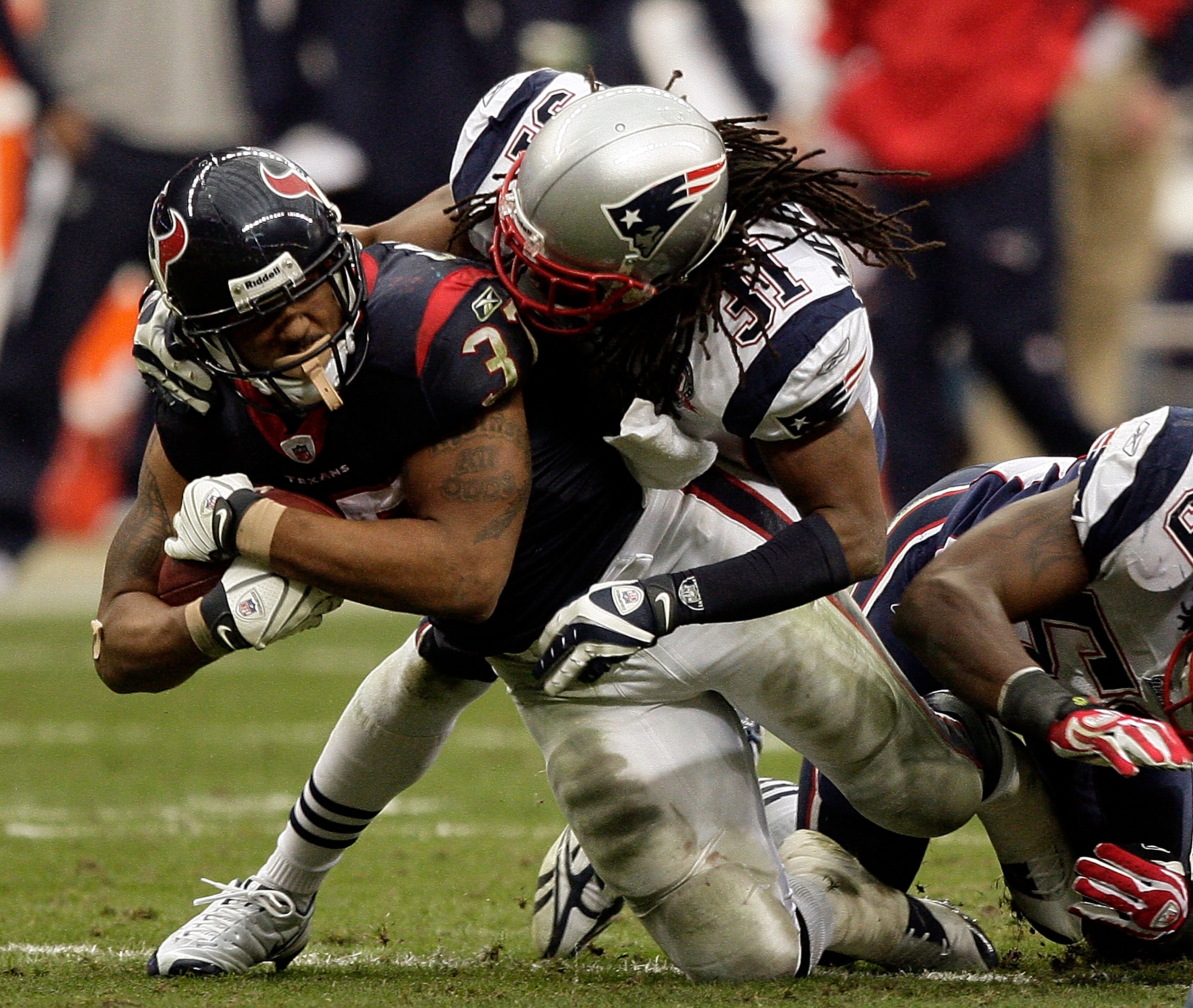 HOUSTON - JANUARY 03:  Running back Arian Foster #37 of the Houston Texans is tackled by safety Brandon Meriweather #31 of the New England Patriots at Reliant Stadium on January 3, 2010 in Houston, Texas.  (Photo by Bob Levey/Getty Images)