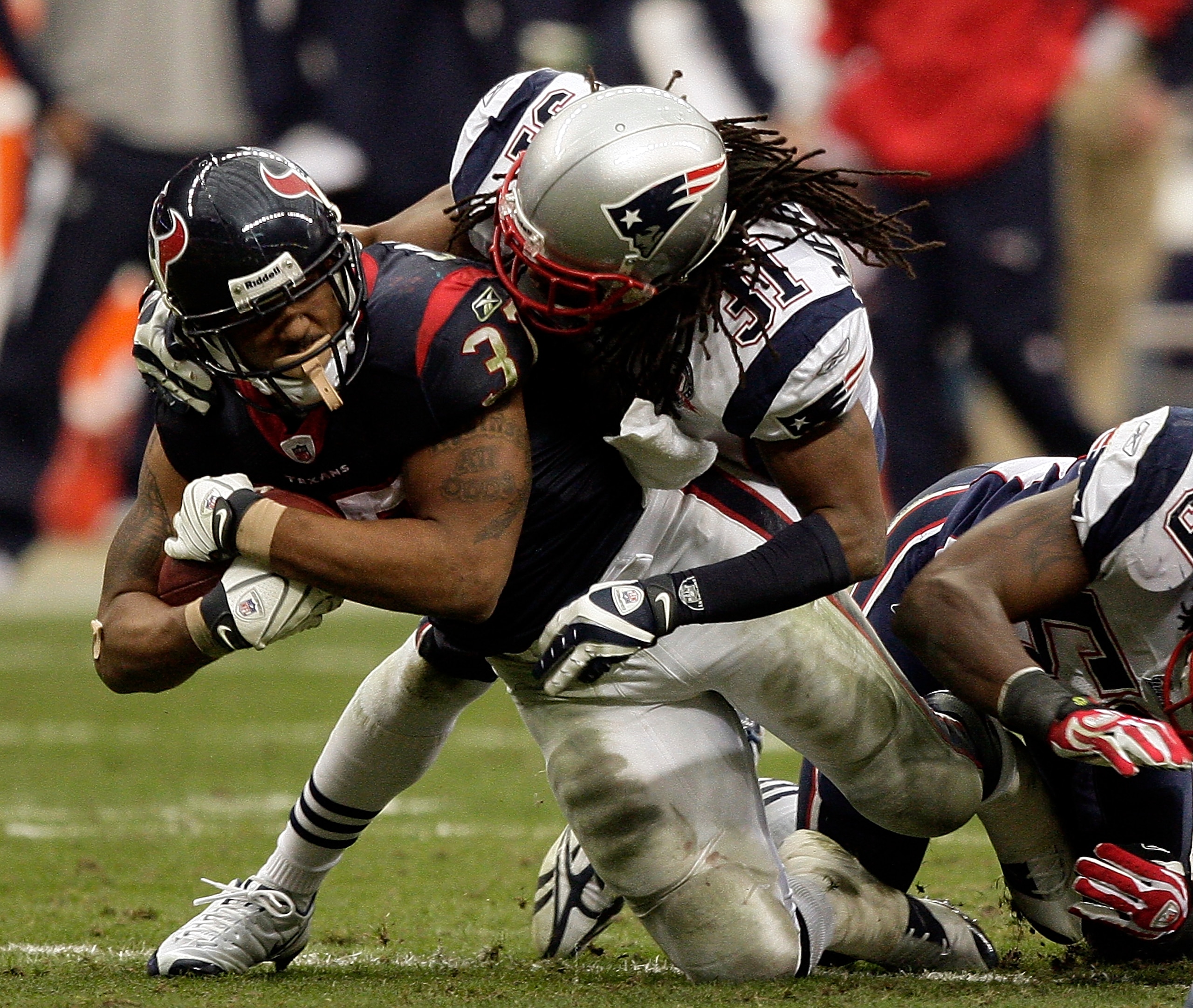 HOUSTON - JANUARY 03:  Running back Arian Foster #37 of the Houston Texans is tackled by safety Brandon Meriweather #31 of the New England Patriots at Reliant Stadium on January 3, 2010 in Houston, Texas.  (Photo by Bob Levey/Getty Images)
