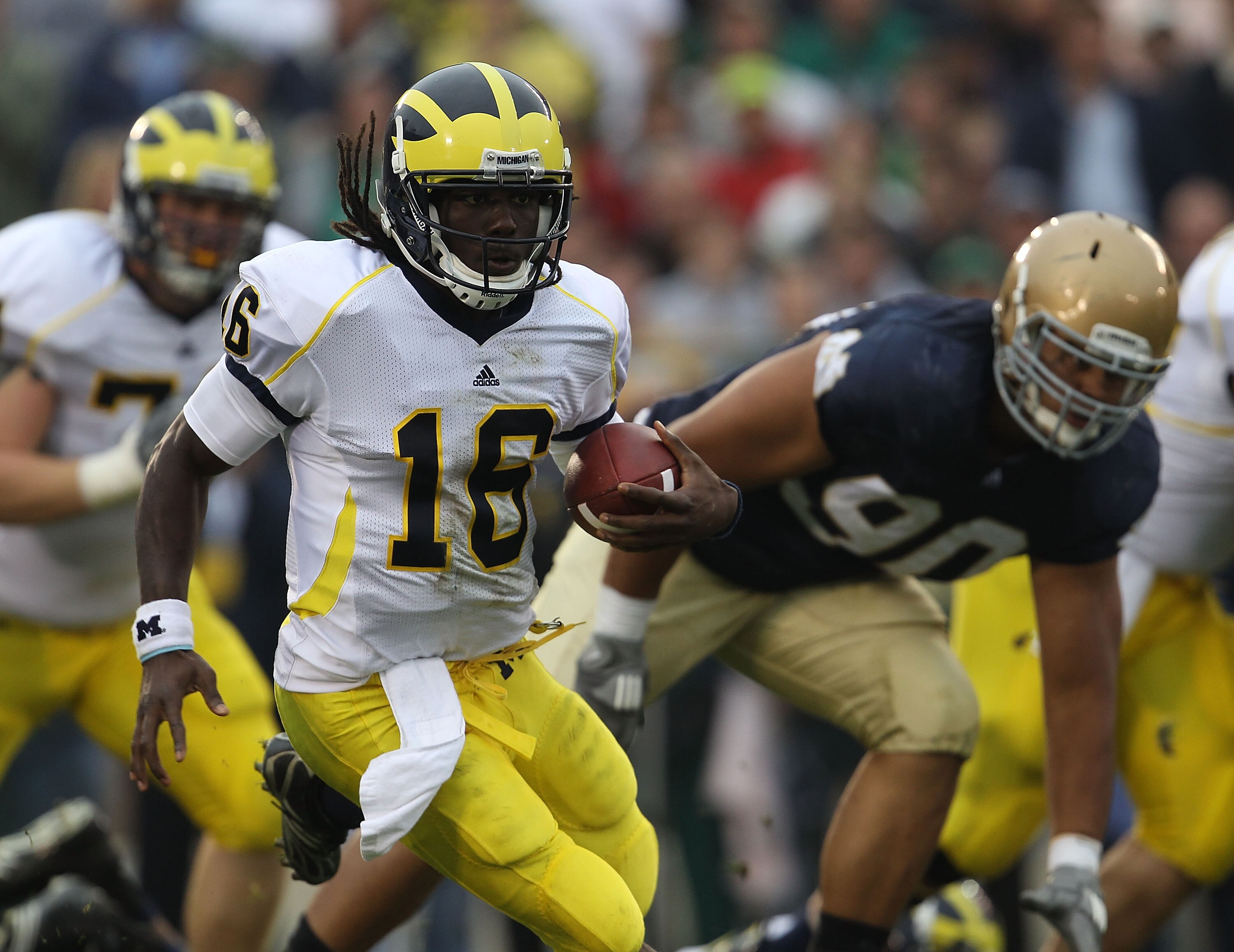 SOUTH BEND, IN - SEPTEMBER 11: Denard Robinson #16 of the Michigan Wolverines runs past Ethan Johnson #90 of the Notre Dame Fighting Irish at Notre Dame Stadium on September 11, 2010 in South Bend, Indiana. Michigan defeated Notre Dame 28-24.  (Photo by J