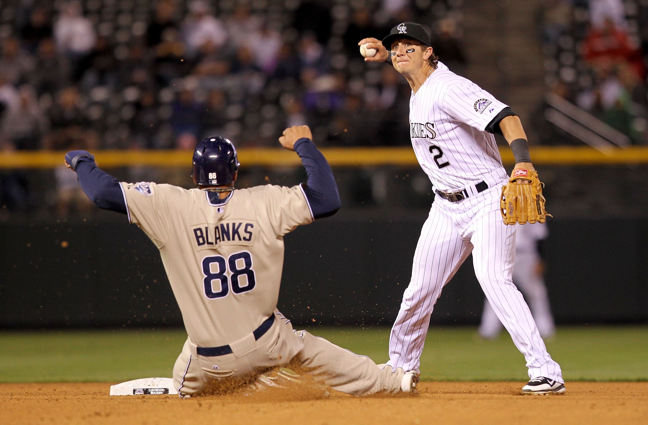 DENVER - APRIL 10:  Shortstop Troy Tulowitzki #2 of the Colorado Rockies turns a double play on Kyle Banks #88 of the San Diego Padres during MLB action at Coors Field on April 10, 2010 in Denver, Colorado. The Padres defeated the Rockies 5-4 in 14 inning