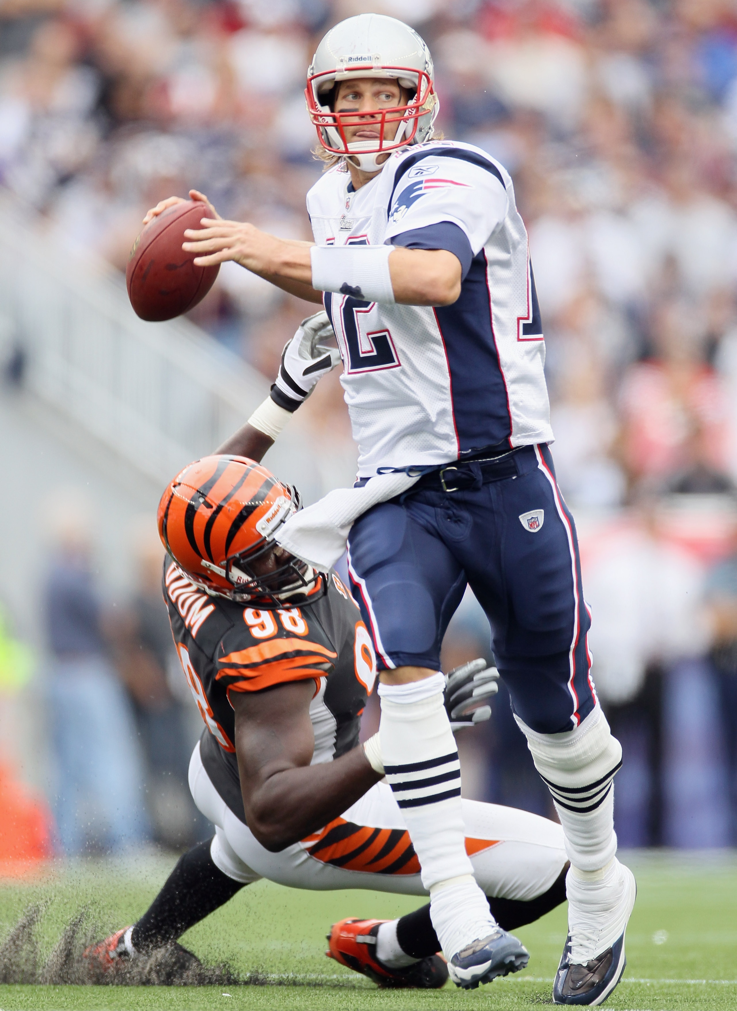 FOXBORO, MA - SEPTEMBER 12:  Tom Brady #12 of the New England Patriots scrambles as Antwan Odom #98 of the Cincinnati Bengals is unable to make the sack during the NFL season opener on September 12, 2010 at Gillette Stadium in Foxboro, Massachusetts.  (Ph