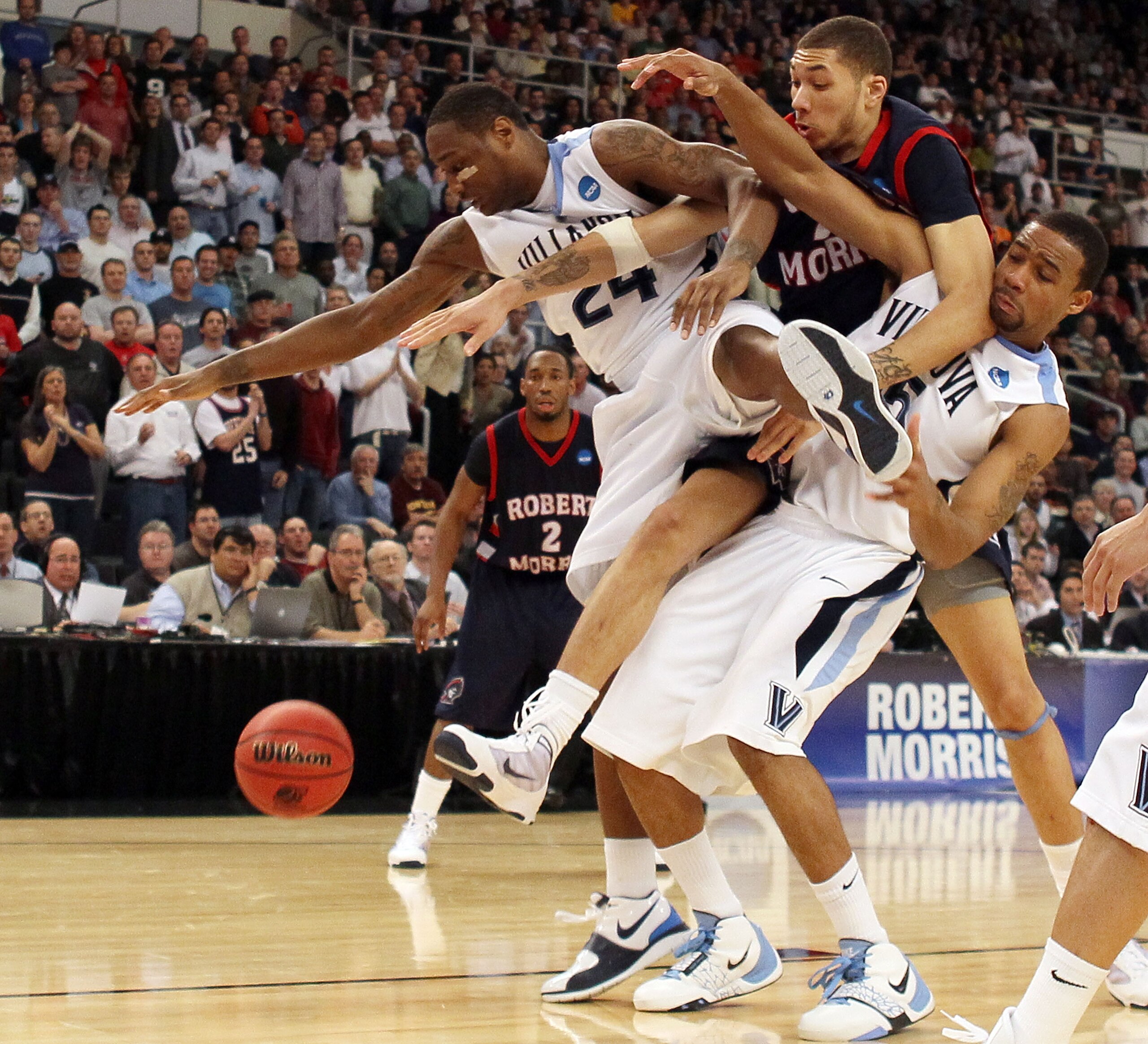 PROVIDENCE, RI - MARCH 18:  Corey Stokes #24 and Maalik Wayns #5 of the Villanova Wildcats fight for the ball with Dallas Green #24 of the Robert Morris Colonials during the first round of the 2010 NCAA men's basketball tournament on March 18, 2010 at the