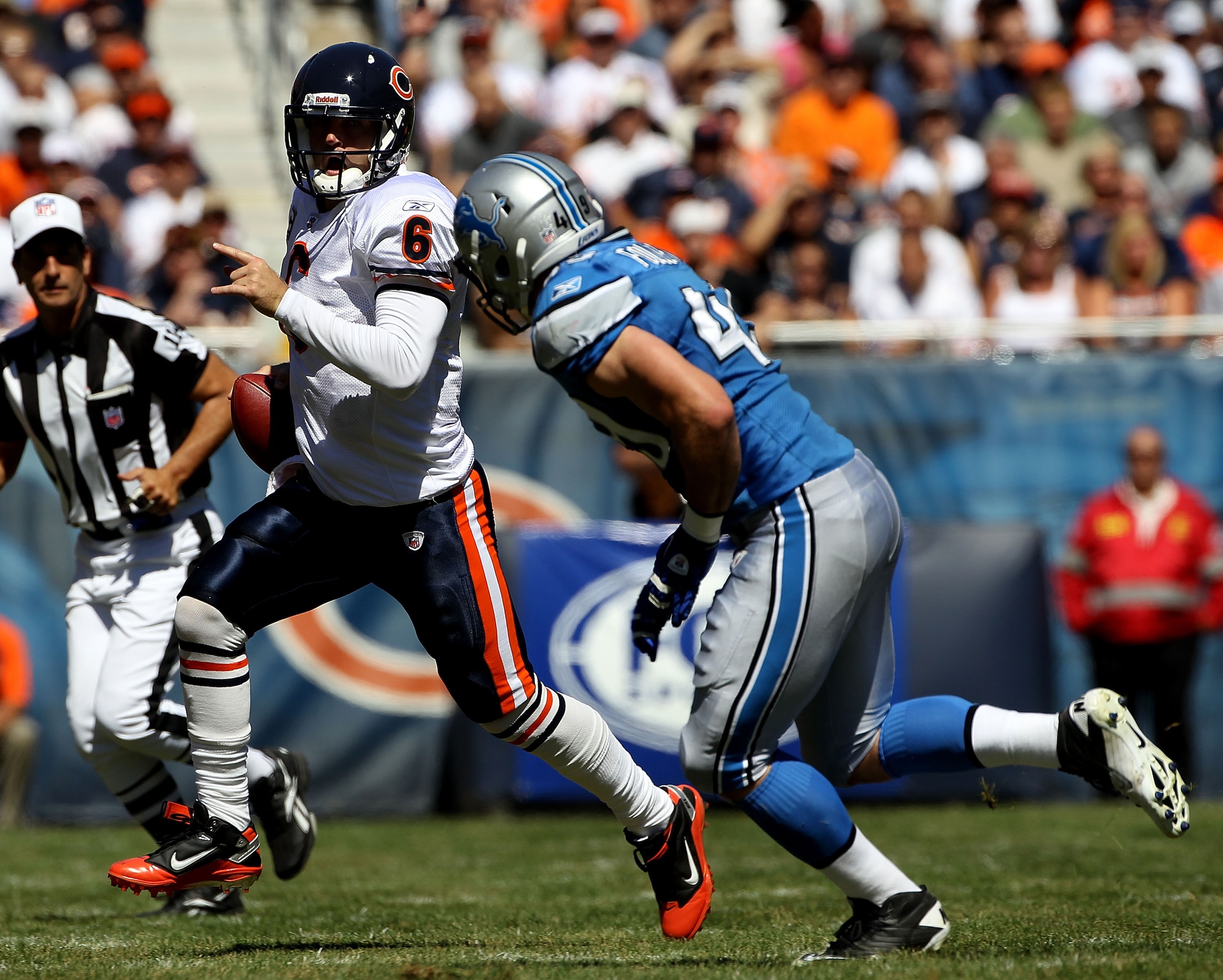 CHICAGO - SEPTEMBER 12: Jay Cutler #6 of the Chicago Bears runs for a first down as Zack Follett #49 of the Detroit Lions pursues during the NFL season opening game at Soldier Field on September 12, 2010 in Chicago, Illinois. The Bears defeated the Lions 