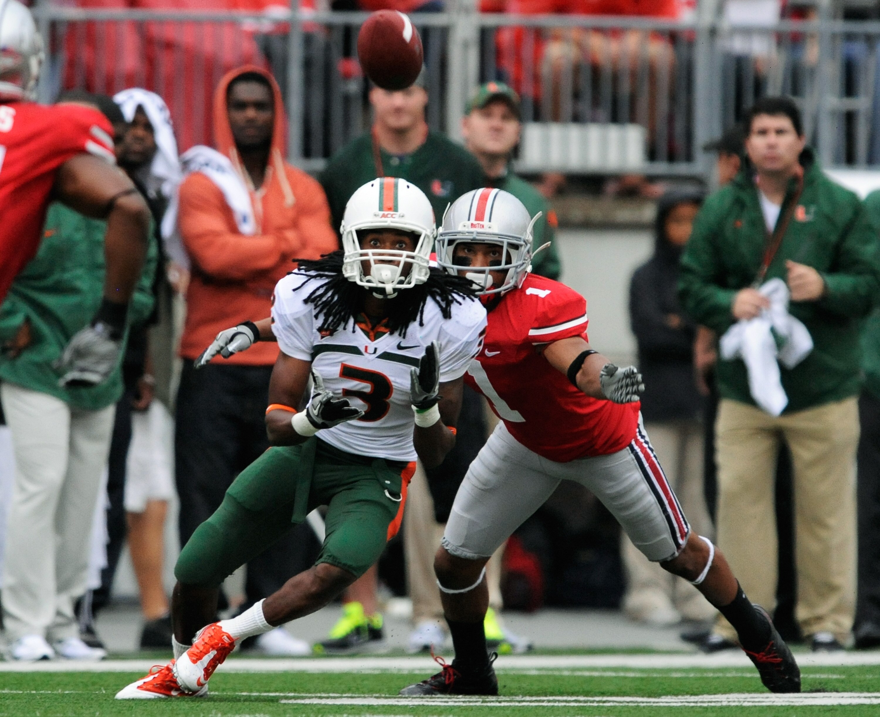 COLUMBUS, OH - SEPTEMBER 11:  Travis Benjamin #3 of the Miami Hurricanes receives a pass as Devon Torrence #1 of the Ohio State Buckeyes defends at Ohio Stadium on September 11, 2010 in Columbus, Ohio.  (Photo by Jamie Sabau/Getty Images)