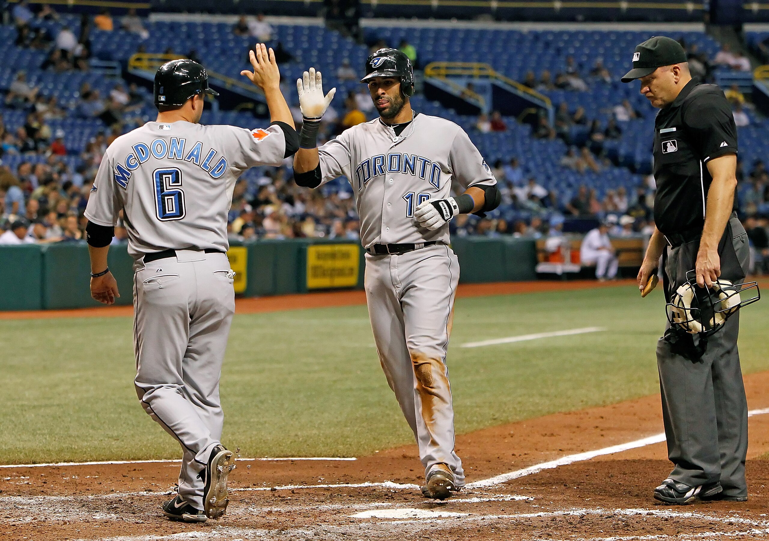 ST. PETERSBURG - AUGUST 31:  Infielder Jose Bautista #19 of the Toronto Blue Jays is congratulated by John McDonald #6 after his home run against the Tampa Bay Rays during the game at Tropicana Field on August 31, 2010 in St. Petersburg, Florida.  (Photo
