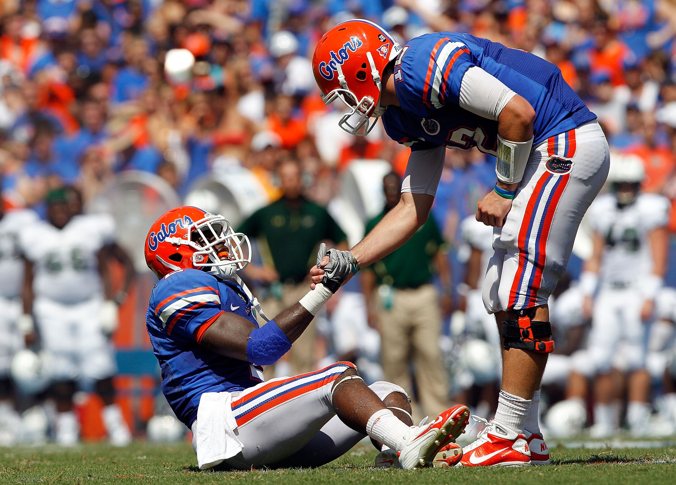 GAINESVILLE, FL - SEPTEMBER 11:  Quarterback John Brantley #12 of the Florida Gators grabs the hand of Jeffery Demps #12 during a game against the South Florida Bulls at Ben Hill Griffin Stadium on September 11, 2010 in Gainesville, Florida.  (Photo by Sa