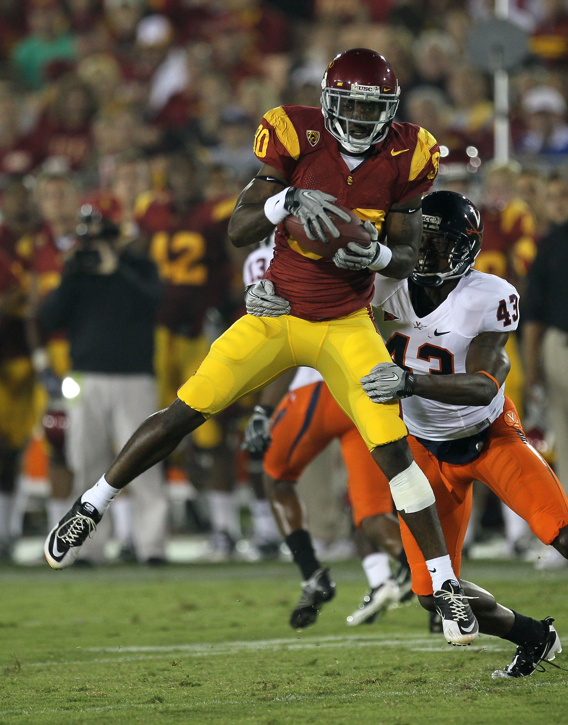 LOS ANGELES - SEPTEMBER 11:  Wide receiver Brandon Carswell #80 of the USC Trojans makes a catch in front of cornerback Mike Parker #43 of the Virginia Cavaliers at Los Angeles Memorial Coliseum on September 11, 2010 in Los Angeles, California. USC won 17