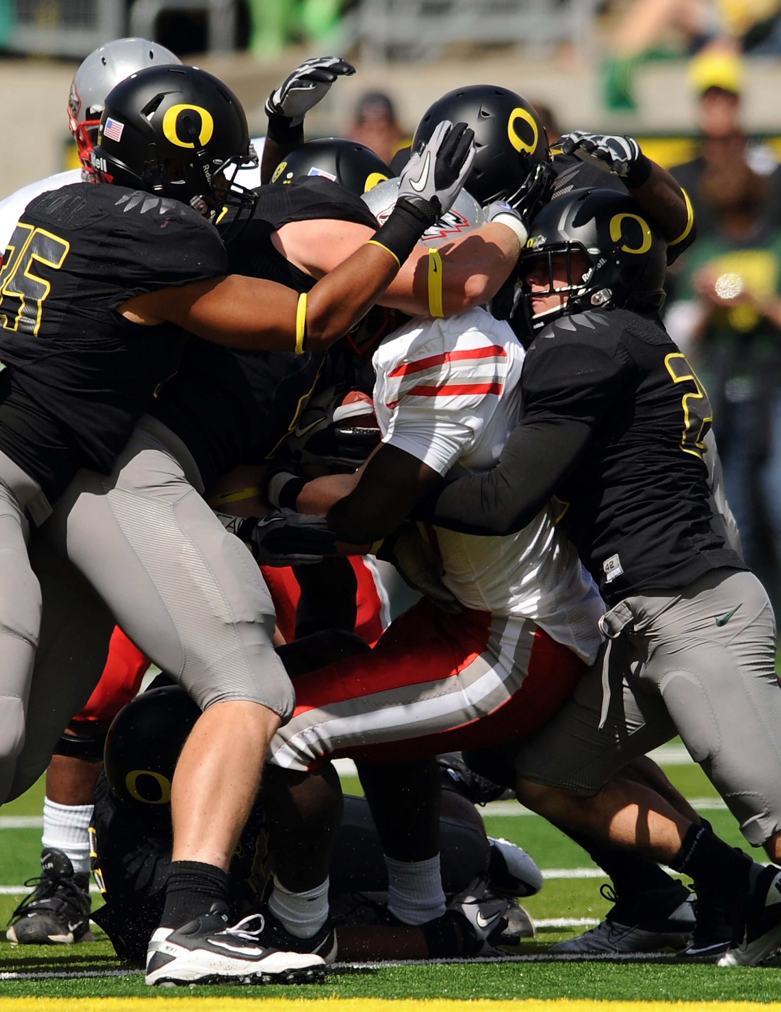 EUGENE, OR - SEPTEMBER 04: Linebacker Casey Matthews #55 of the Oregon Ducks (L) and free safety John Boyett #20 of the Oregon Ducks (R) gang up to tackle running back Demond Dennis #1 of the New Mexico Lobos in the first quarter of the game at Autzen Sta EUGENE, OR - SEPTEMBER 04: Linebacker Casey Matthews #55 of the Oregon Ducks (L) and free safety John Boyett #20 of the Oregon Ducks (R) gang up to tackle running back Demond Dennis #1 of the New Mexico Lobos in the first quarter of the game at Autzen Sta