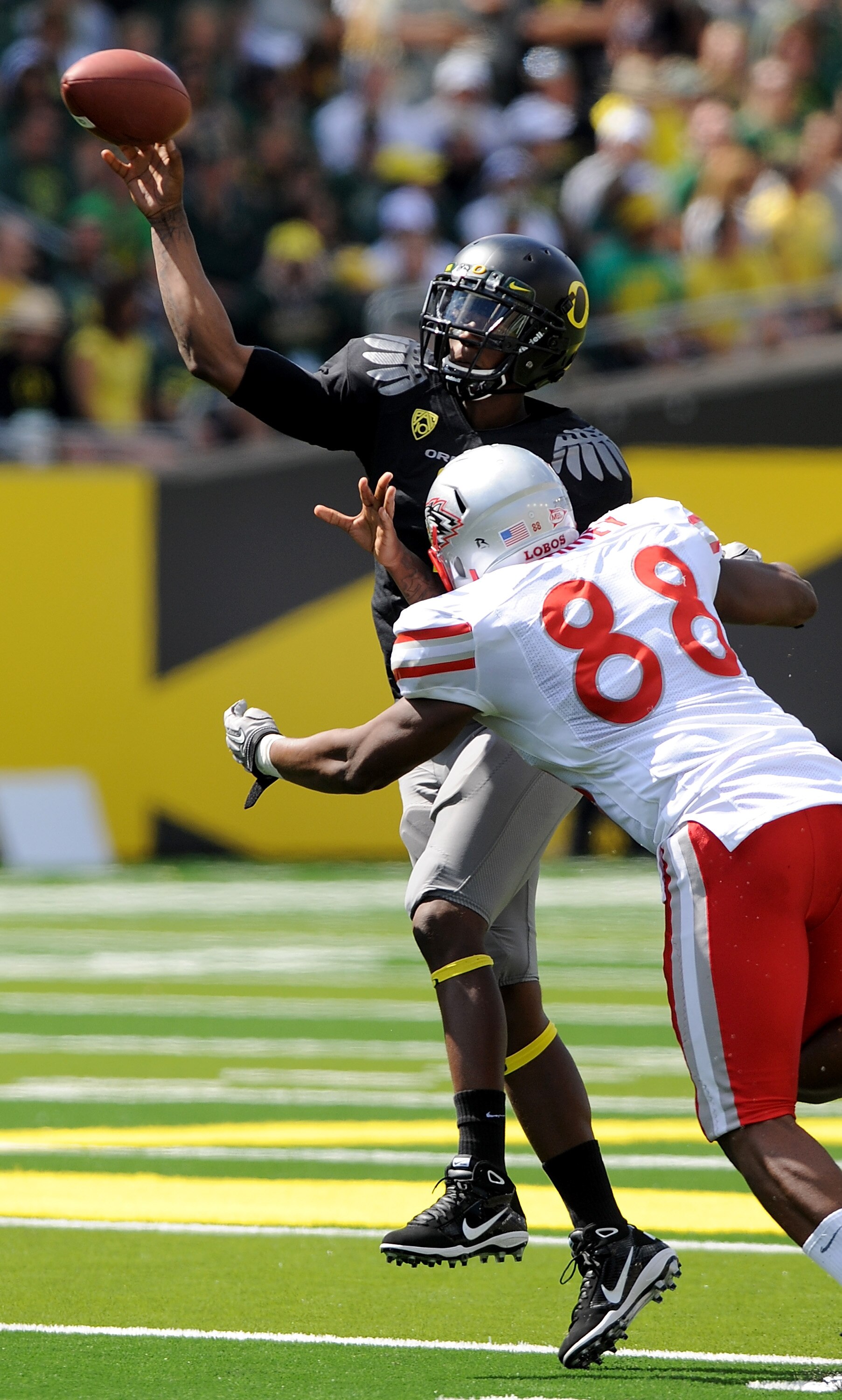 EUGENE, OR - SEPTEMBER 04:  Quarterback Darron Thomas #1 of the Oregon Ducks throws a pass as he is pressured by defensive end Johnathan Rainey #88 of the New Mexico Lobos in the first quarter of the game at Autzen Stadium on September 4, 2010 in Eugene,