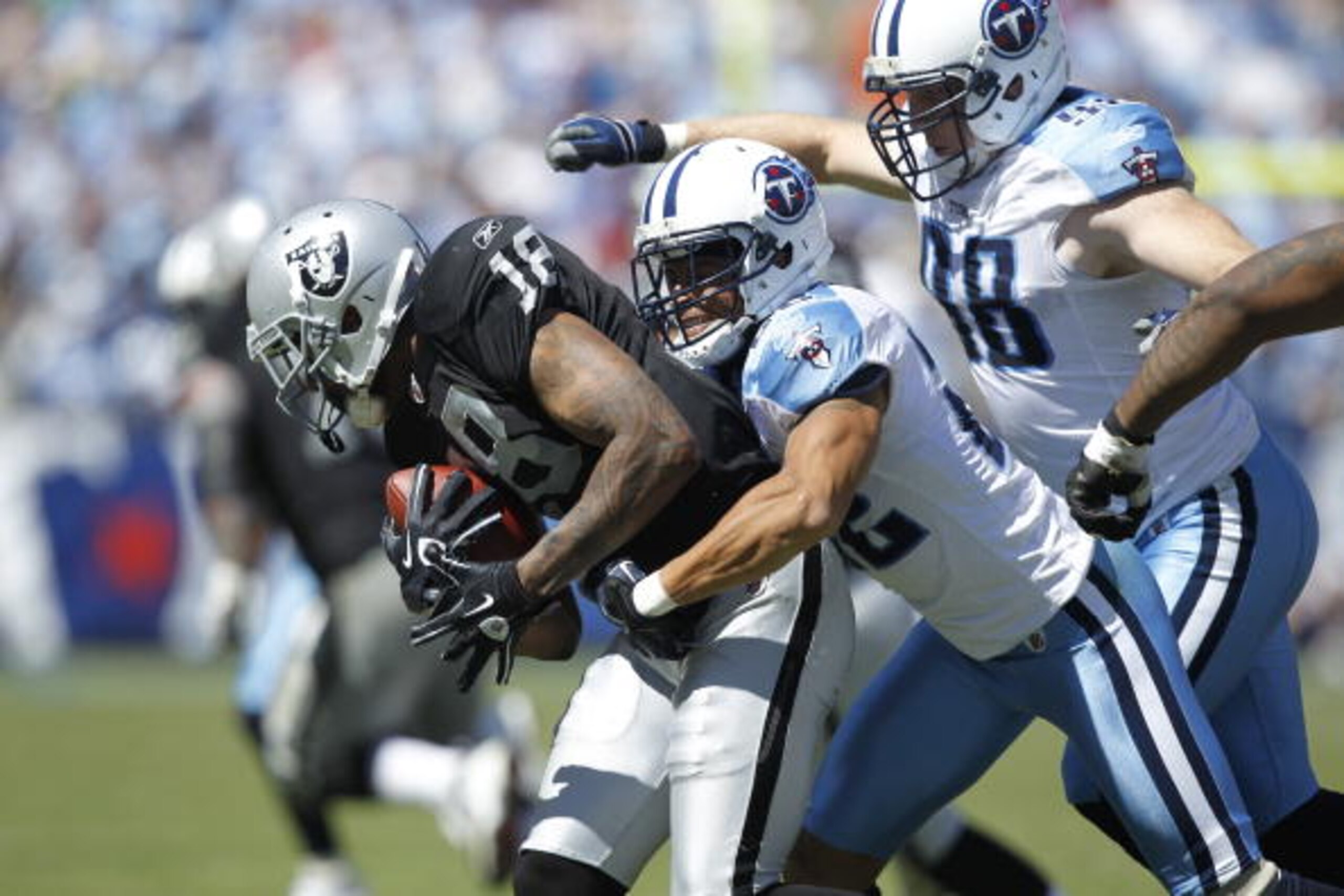 NASHVILLE - SEPTEMBER 12: Vincent Fuller #22 and Dave Ball #98 of the Tennessee Titans tackle Louis Murphy #18 of the Oakland Raiders during the NFL season opener at LP Field on September 12, 2010 in Nashville, Tennessee. The Titans defeated the Raiders 3
