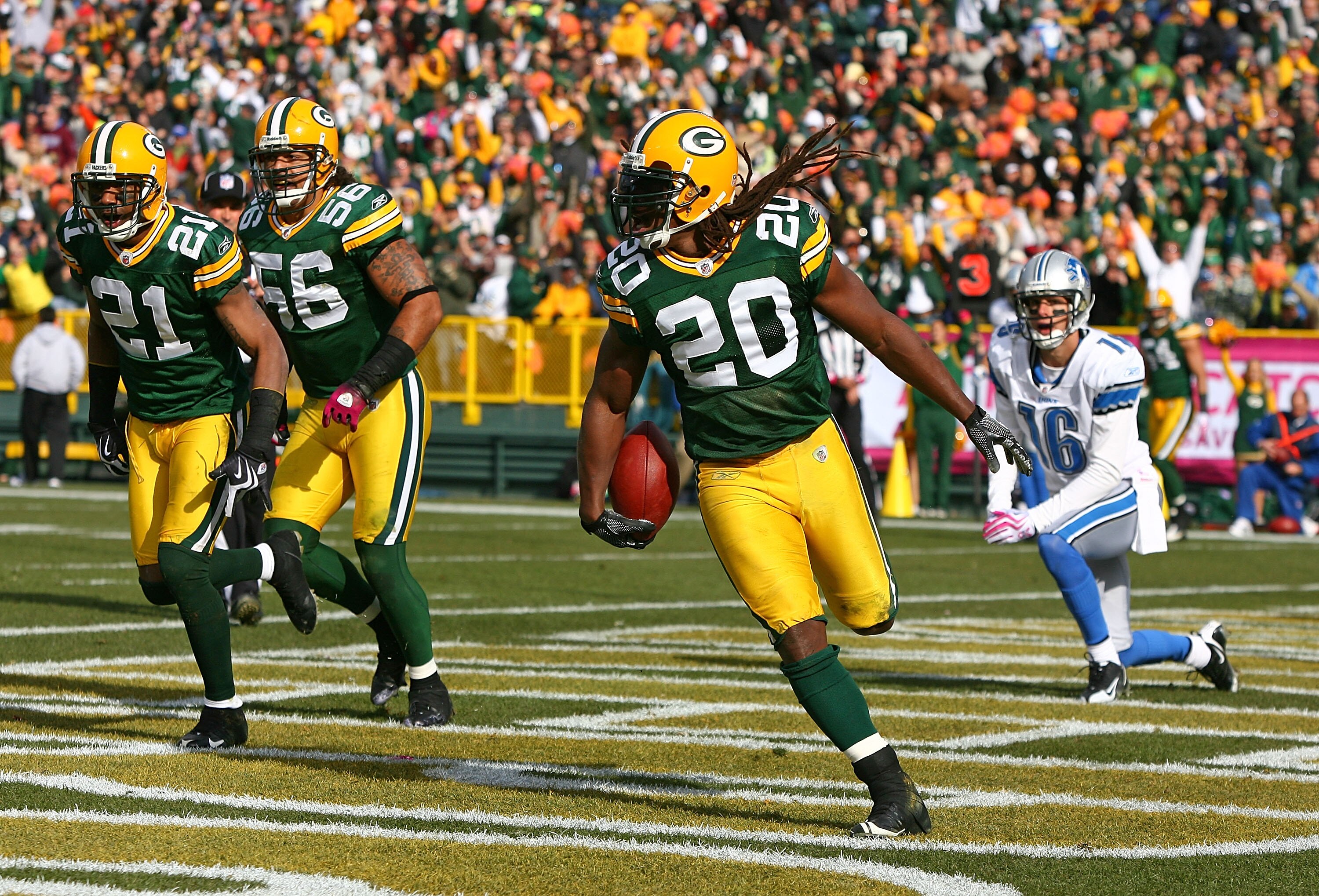 GREEN BAY, WI - OCTOBER 18: Atari Bigby #20 of the Green Bay Packers celebrates an interception in the end zone on a pass intended for John Standeford #16 of the Detroit Lions as teammates Charles Woodson #21 and Nick Barnett#56 run off the field at Lambe