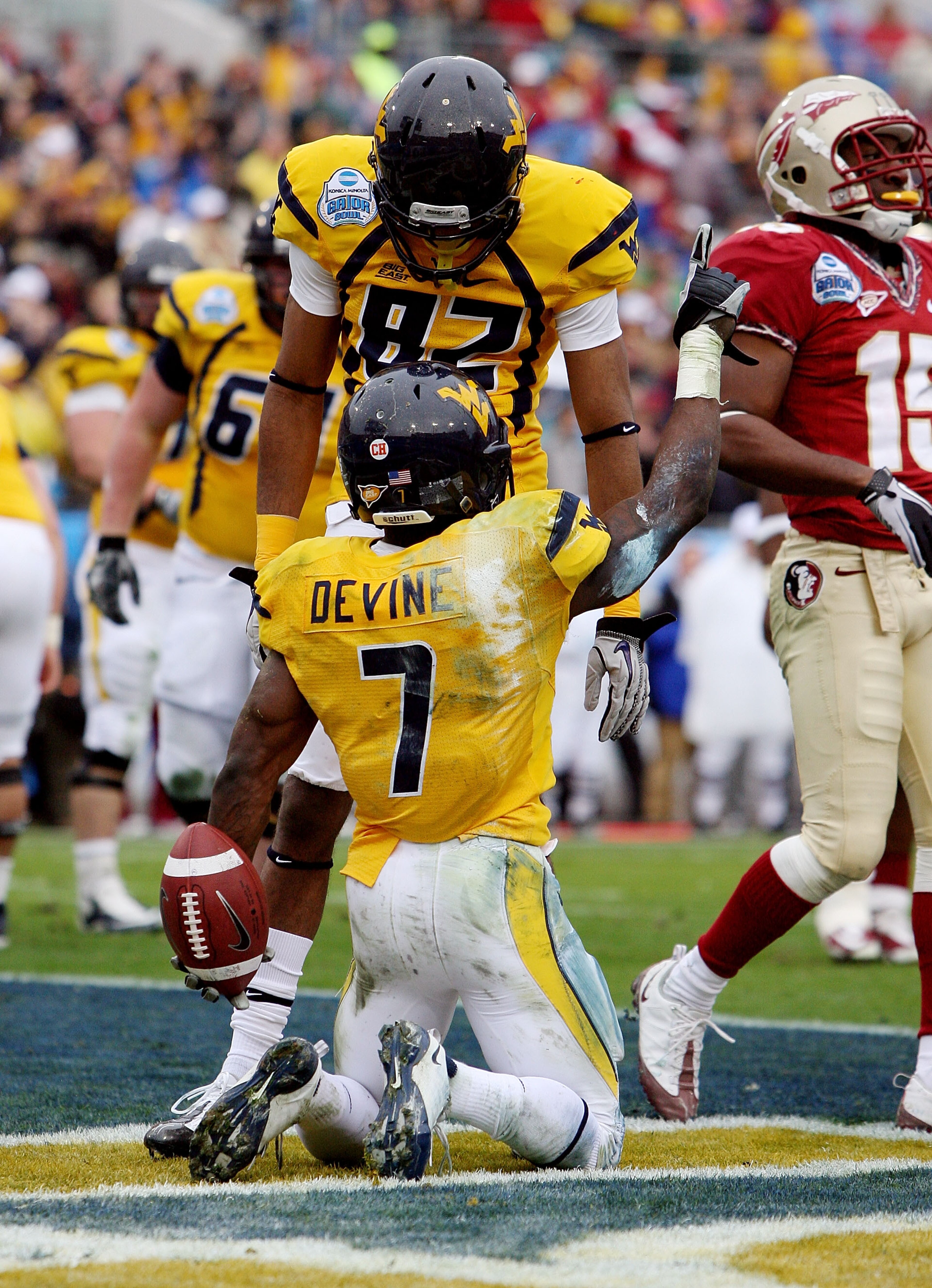 JACKSONVILLE, FL - JANUARY 01: Running back Noel Devine #7 and wide receiver Alric Arnett #82 of the West Virginia Mountaineers celebrate Devine's first quarter touchdown in the first quarter against the Florida State Seminoles during the Konica Minolta G