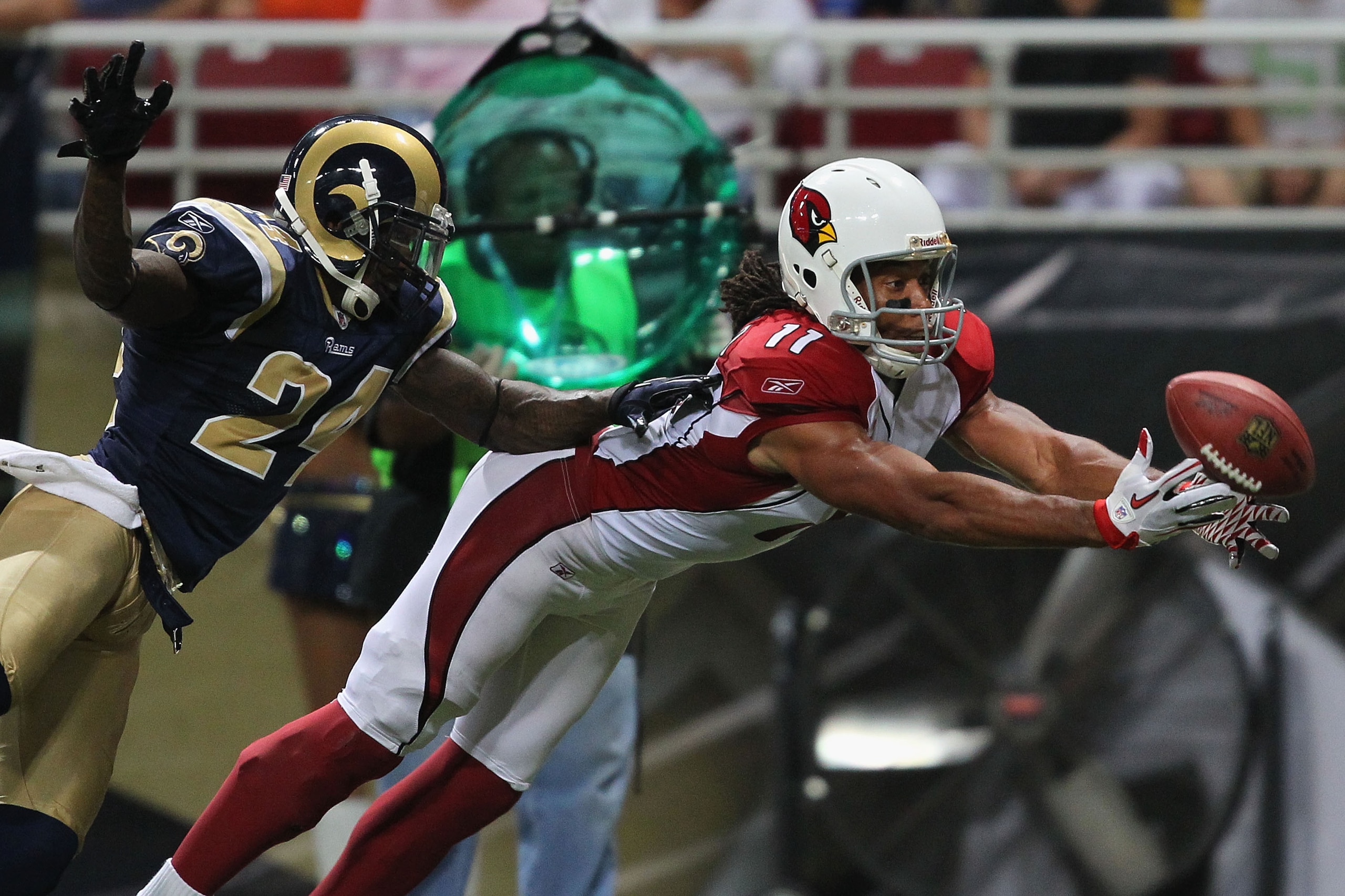 ST. LOUIS - SEPTEMBER 12: Larry Fitzgerald #11 of the Arizona Cardinals looks to haul in a touchdown pass against Ron Bartell #24 of the St. Louis Rams during the NFL season opener at the Edward Jones Dome on September 12, 2010 in St. Louis, Missouri.  Th
